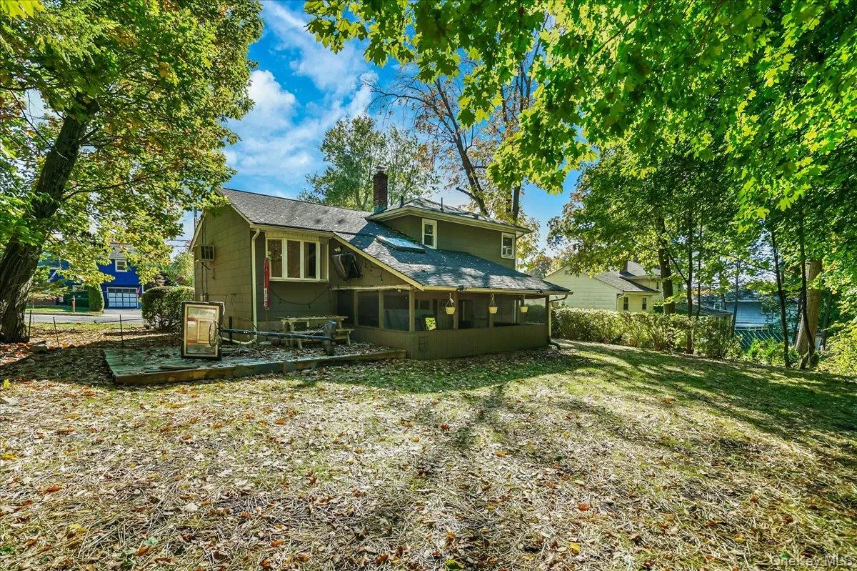 Rear view of property with a sunroom and a yard Rear view of property with a sunroom and a yard