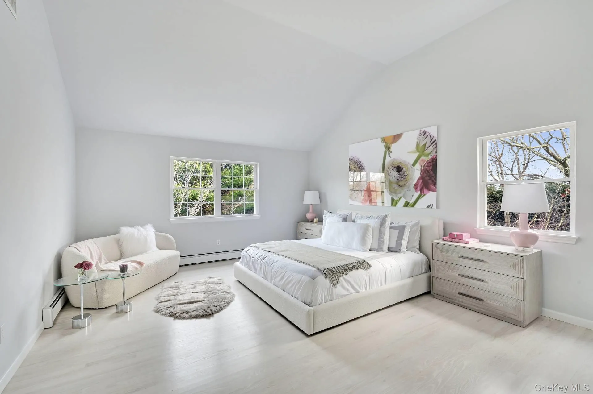 Bedroom featuring wood finished floors, baseboard heating, and high vaulted ceiling Bedroom featuring wood finished floors, baseboard heating, and high vaulted ceiling