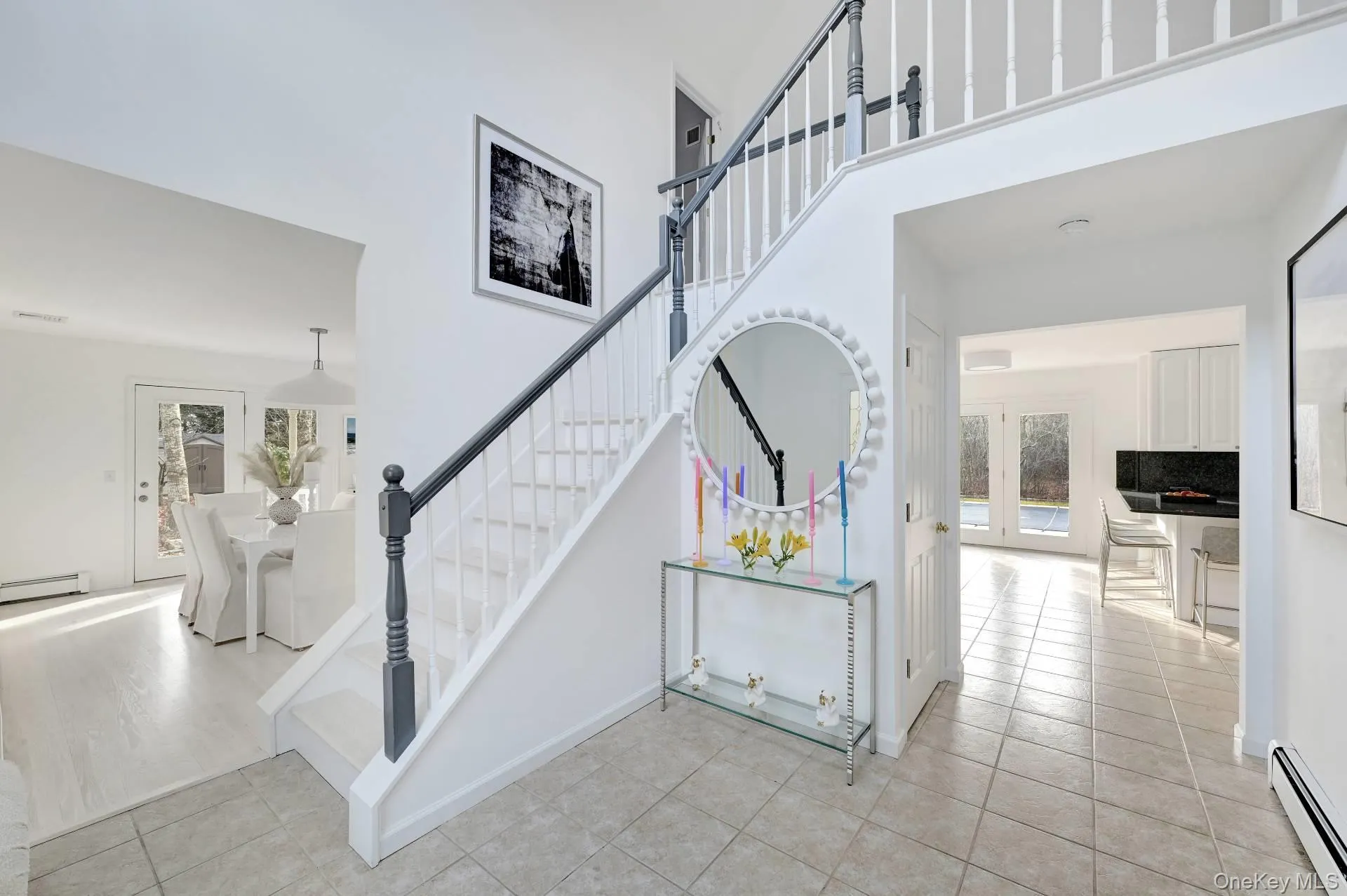 Stairway with a baseboard heating unit, tile patterned flooring, and a towering ceiling Stairway with a baseboard heating unit, tile patterned flooring, and a towering ceiling