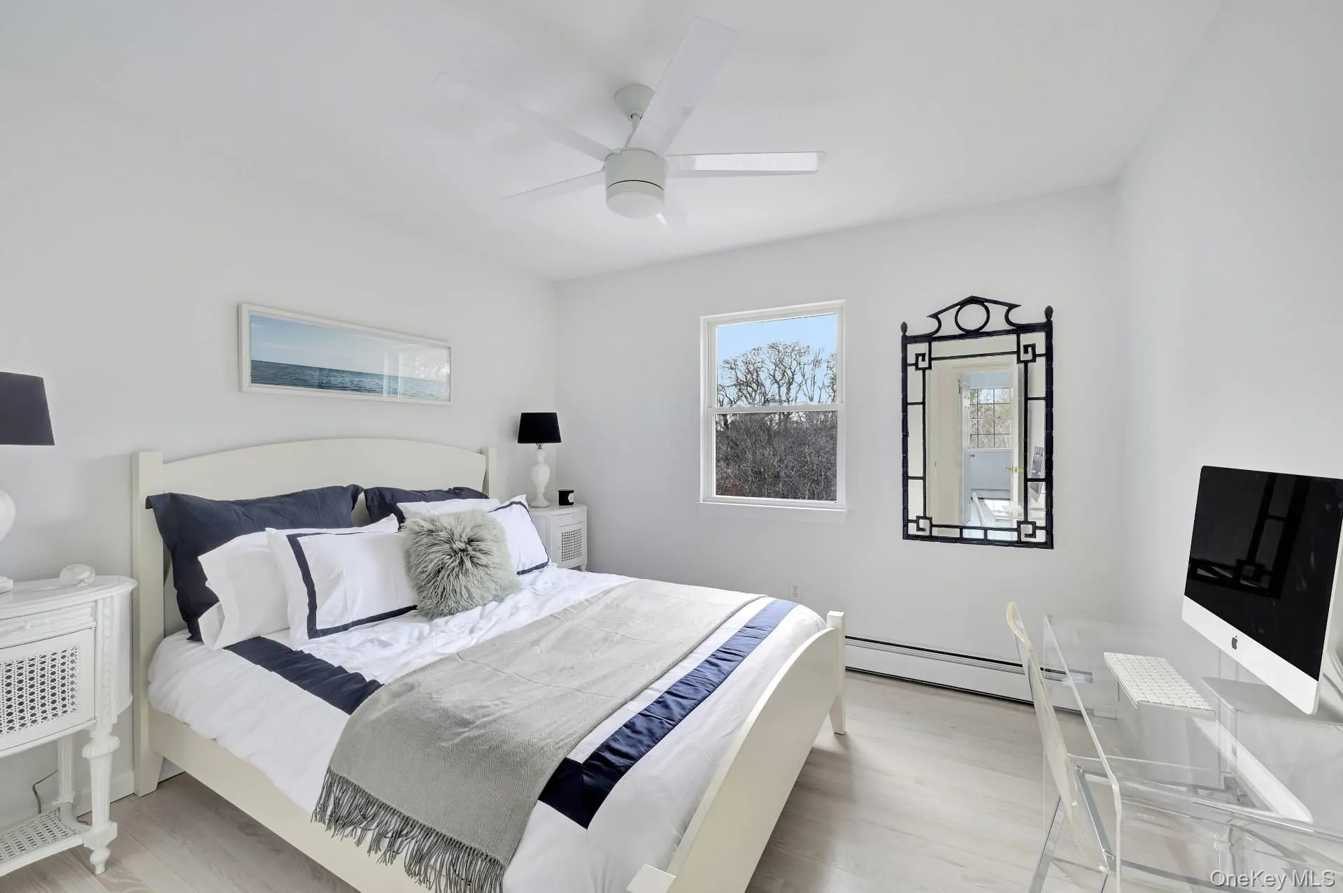 Bedroom featuring light wood-style floors, a ceiling fan, and a baseboard radiator Bedroom featuring light wood-style floors, a ceiling fan, and a baseboard radiator
