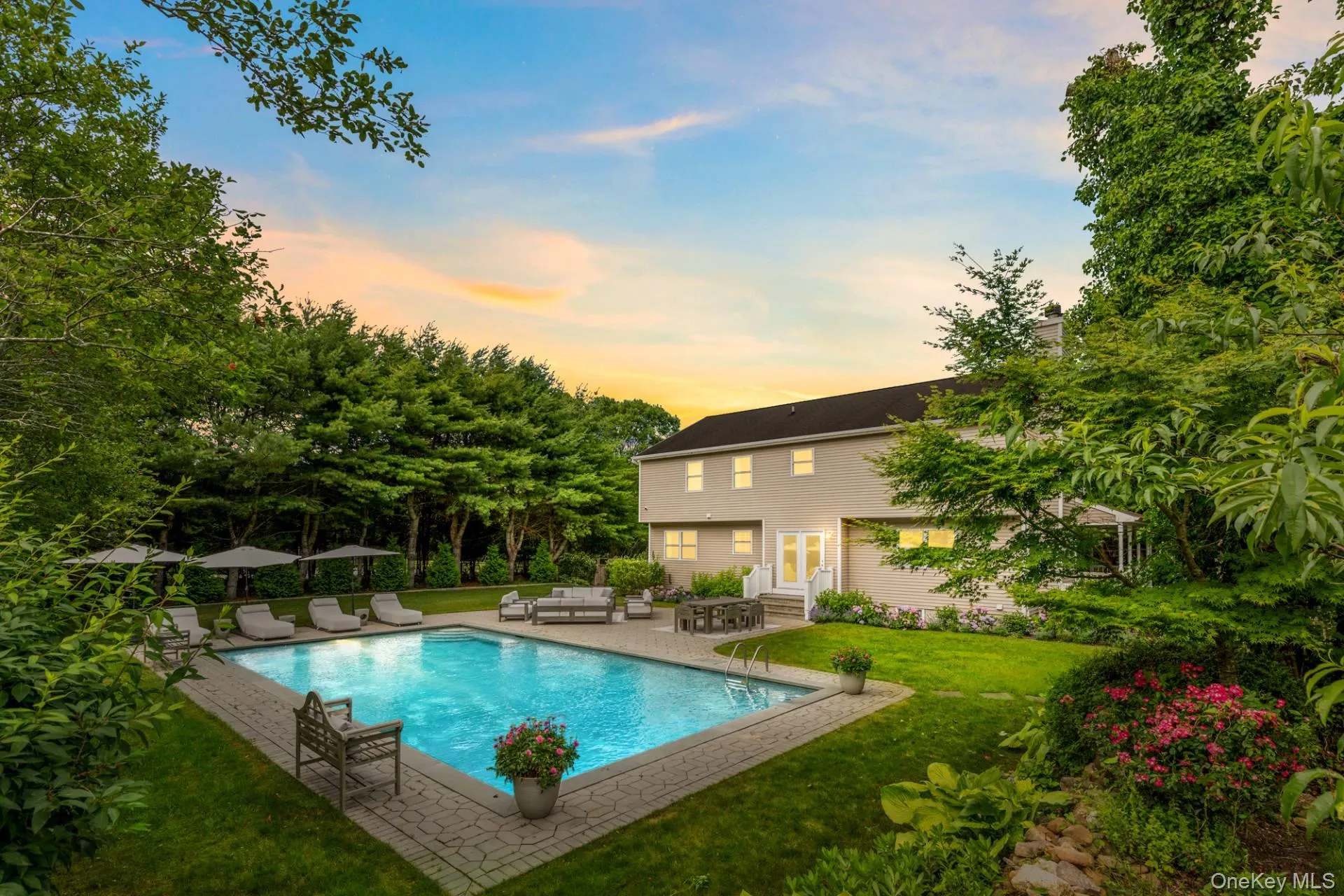 Pool at dusk featuring a patio, a yard, an outdoor hangout area, and entry steps Pool at dusk featuring a patio, a yard, an outdoor hangout area, and entry steps