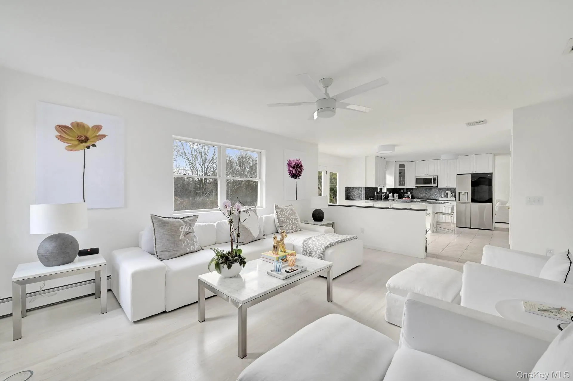 Living area with a ceiling fan and light wood-style flooring Living area with a ceiling fan and light wood-style flooring