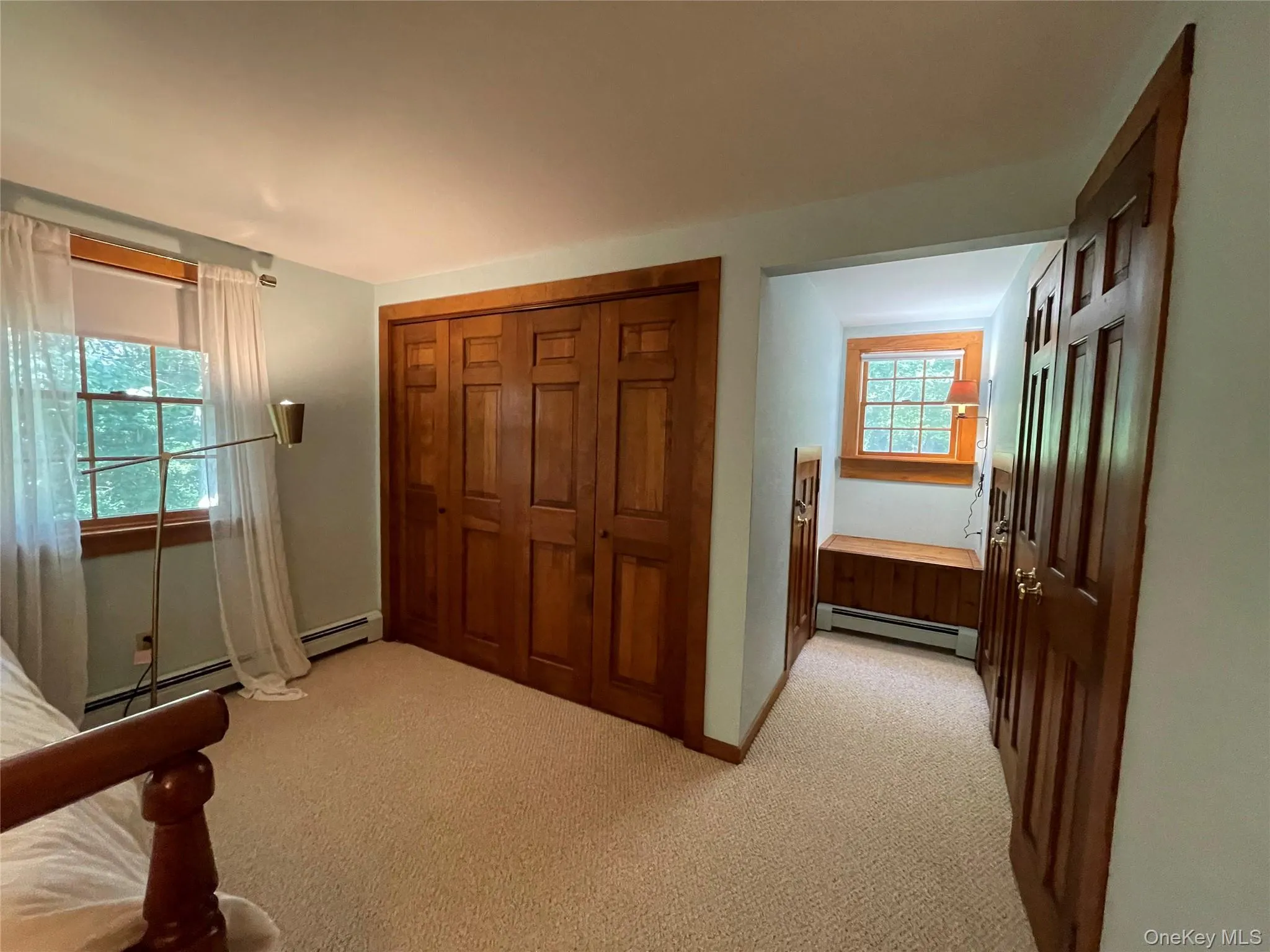 Carpeted bedroom with a closet and a baseboard heating unit Carpeted bedroom with a closet and a baseboard heating unit