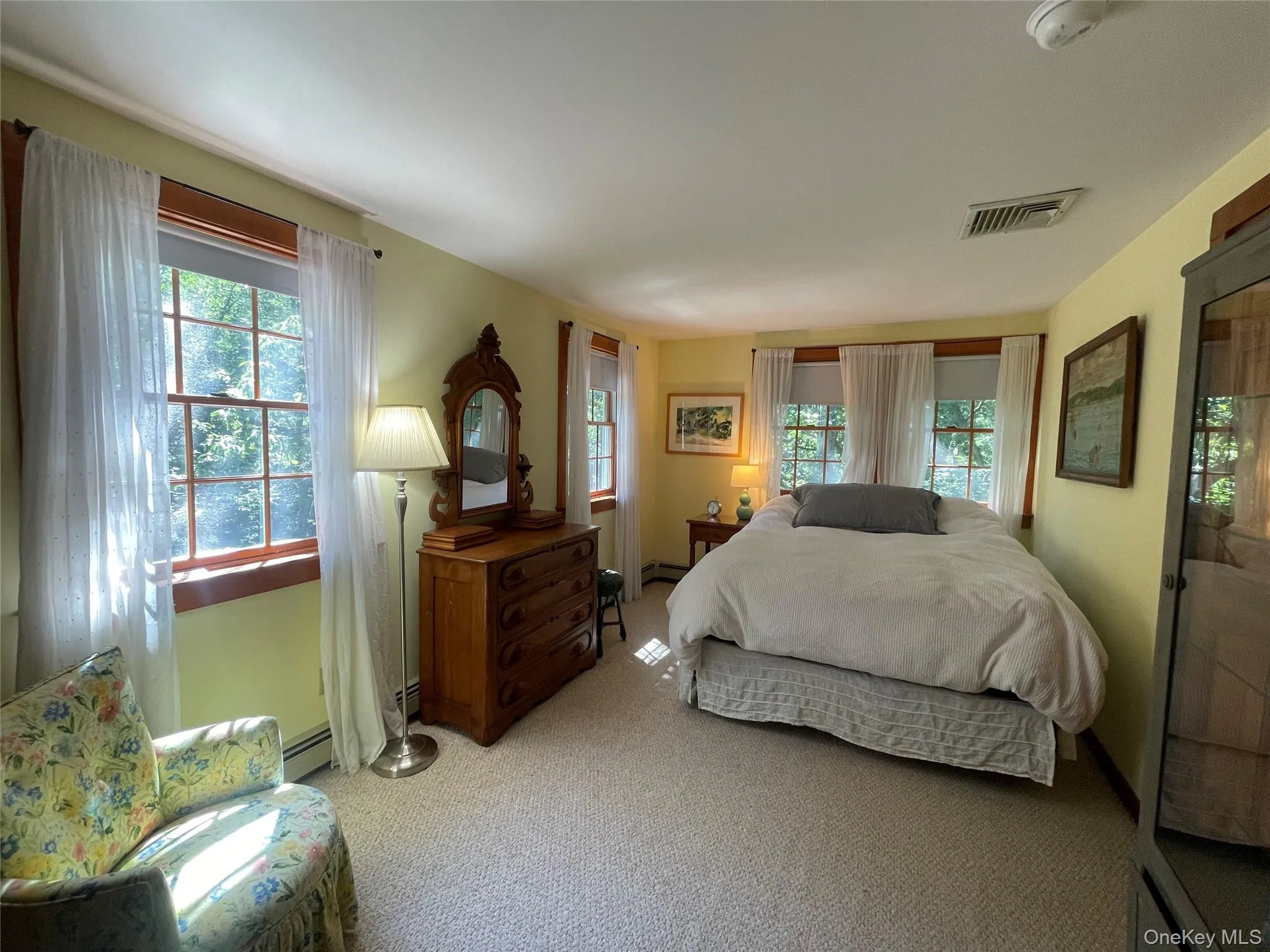 Bedroom featuring light carpet and multiple windows Bedroom featuring light carpet and multiple windows