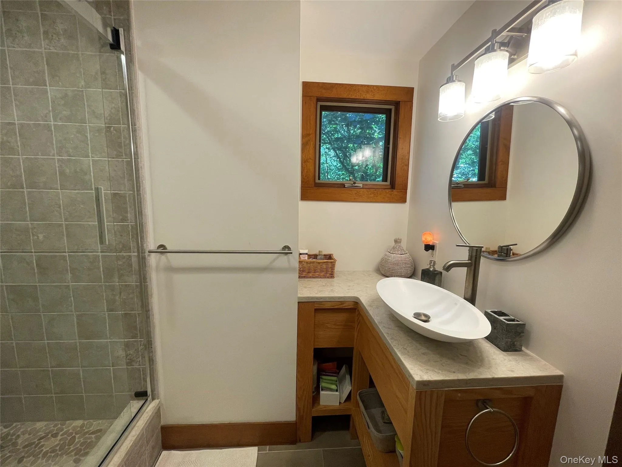 Bathroom featuring vanity, a stall shower, and dark tile patterned flooring Bathroom featuring vanity, a stall shower, and dark tile patterned flooring