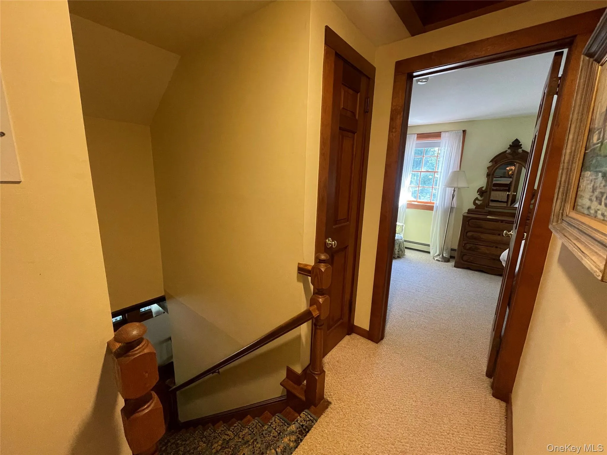 Hallway with an upstairs landing and light colored carpet Hallway with an upstairs landing and light colored carpet