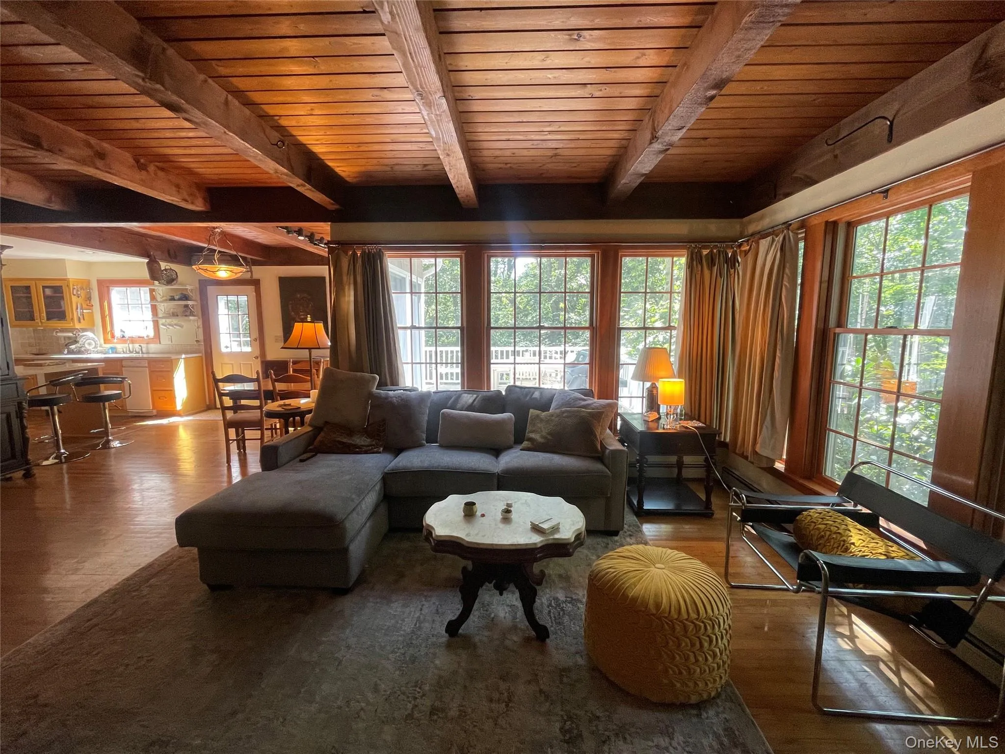 Living room featuring dark wood-type flooring and a wooden ceiling with exposed beams Living room featuring dark wood-type flooring and a wooden ceiling with exposed beams