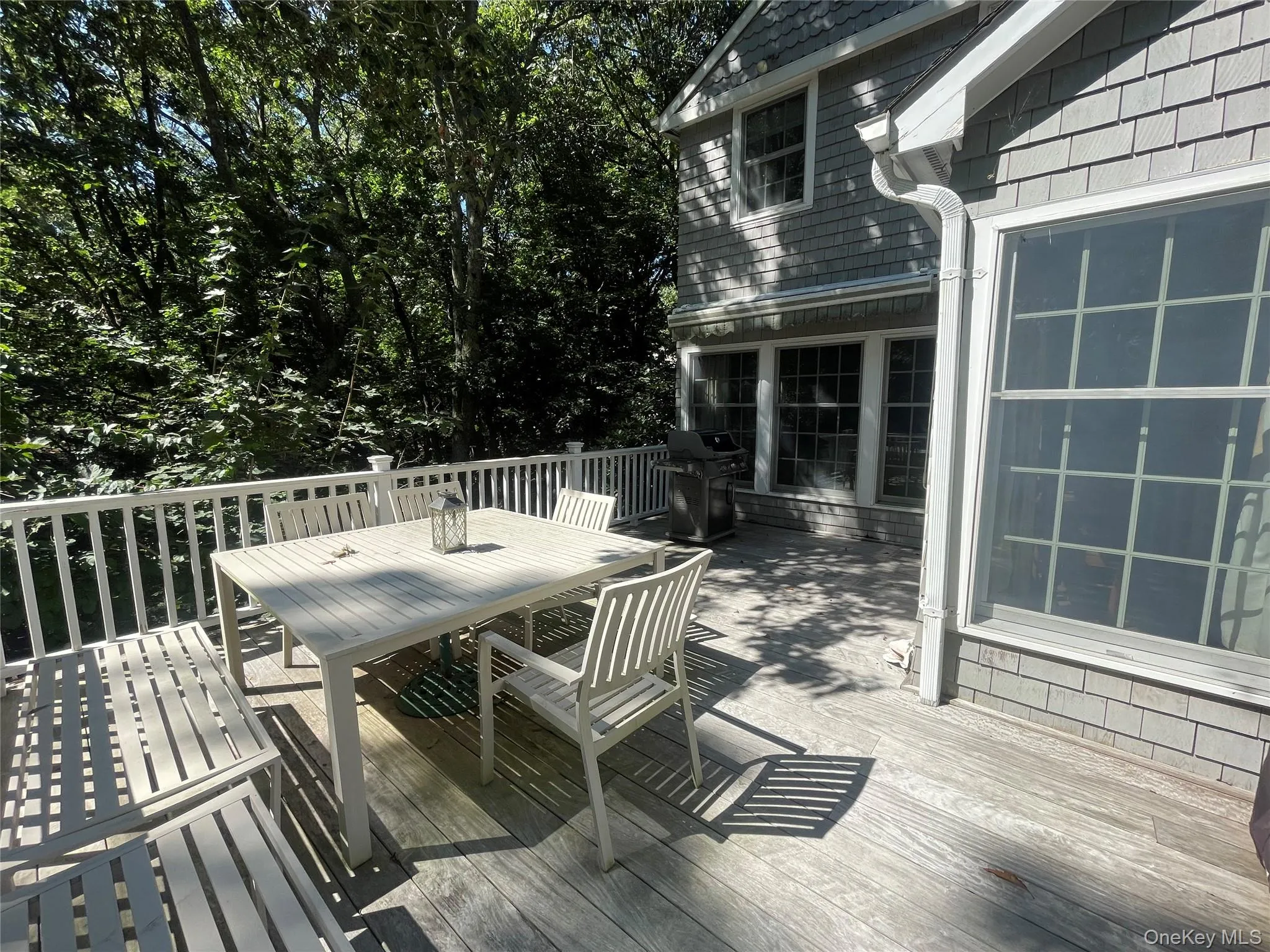 Wooden deck with outdoor dining area and a grill Wooden deck with outdoor dining area and a grill