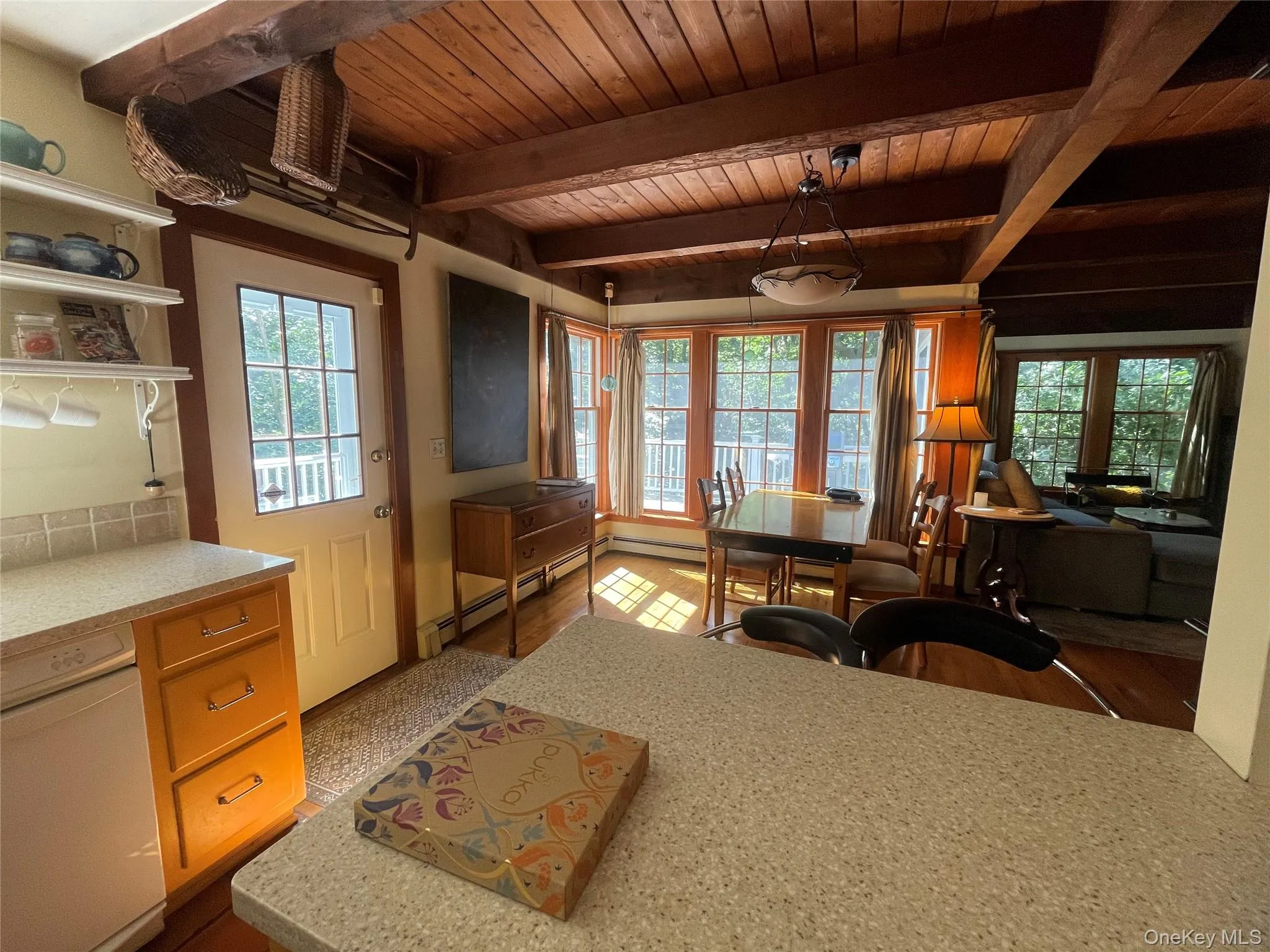 Dining area with a baseboard radiator and a wood ceiling with exposed beams Dining area with a baseboard radiator and a wood ceiling with exposed beams