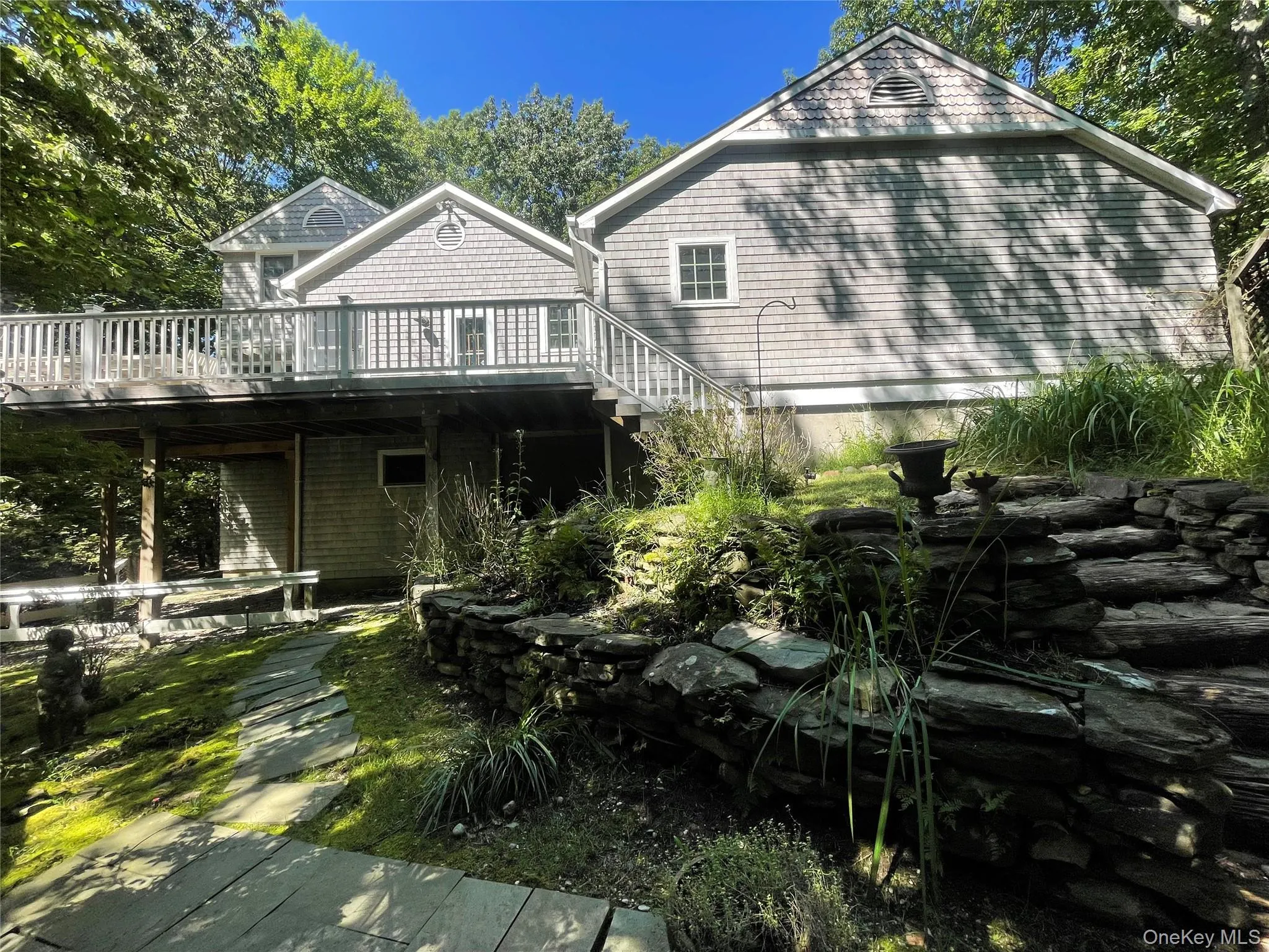 Rear view of house featuring a deck and stairway Rear view of house featuring a deck and stairway