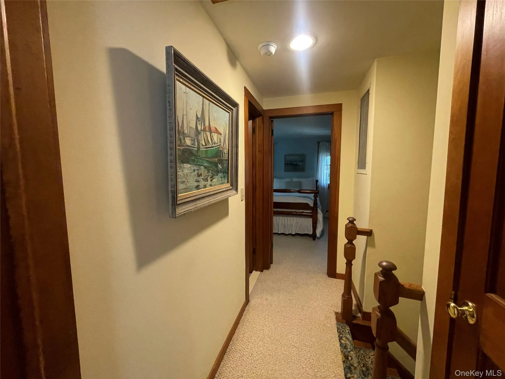 Corridor featuring light colored carpet and an upstairs landing Corridor featuring light colored carpet and an upstairs landing