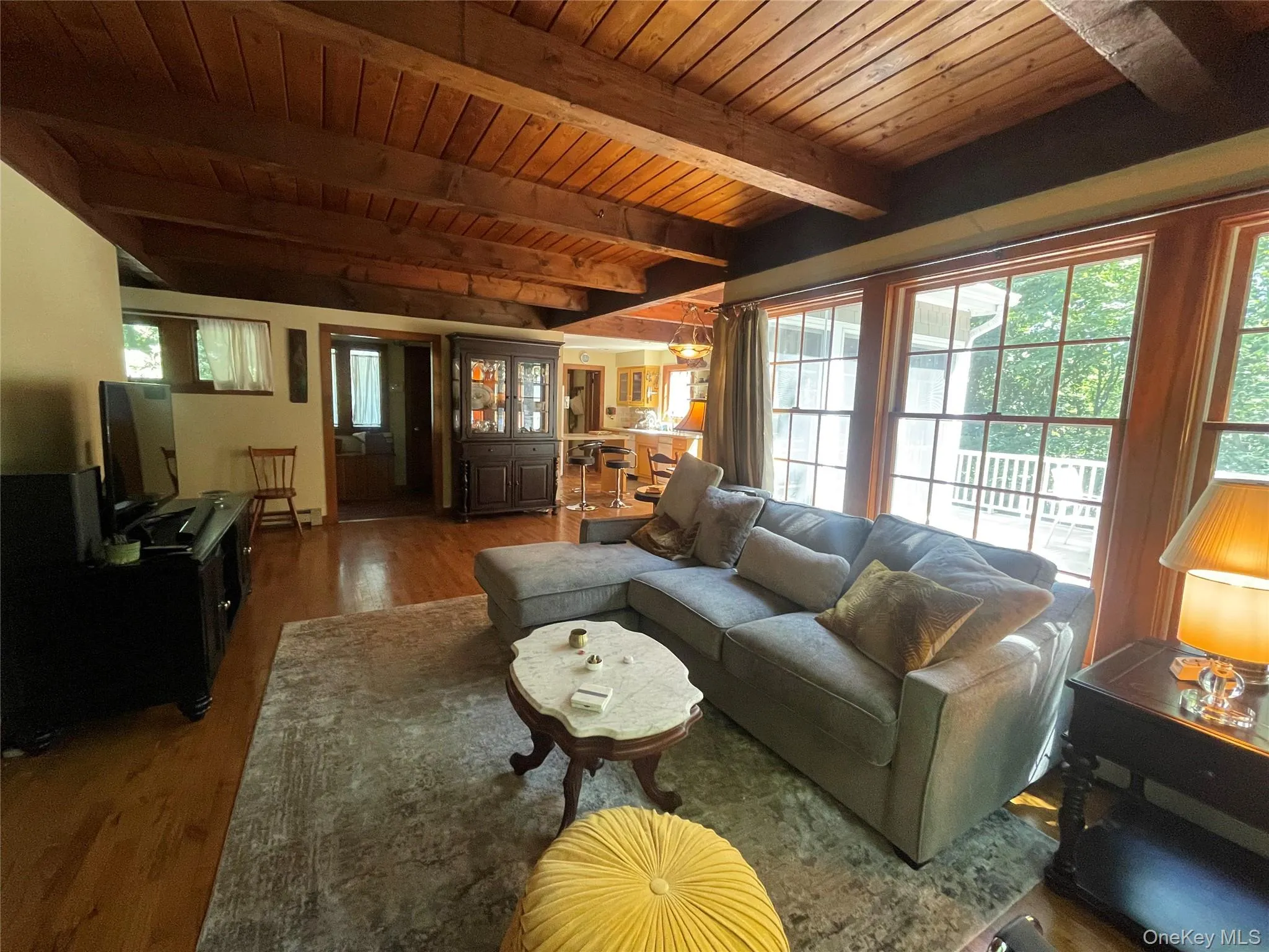 Living area with wood finished floors and a wood ceiling with exposed beams Living area with wood finished floors and a wood ceiling with exposed beams