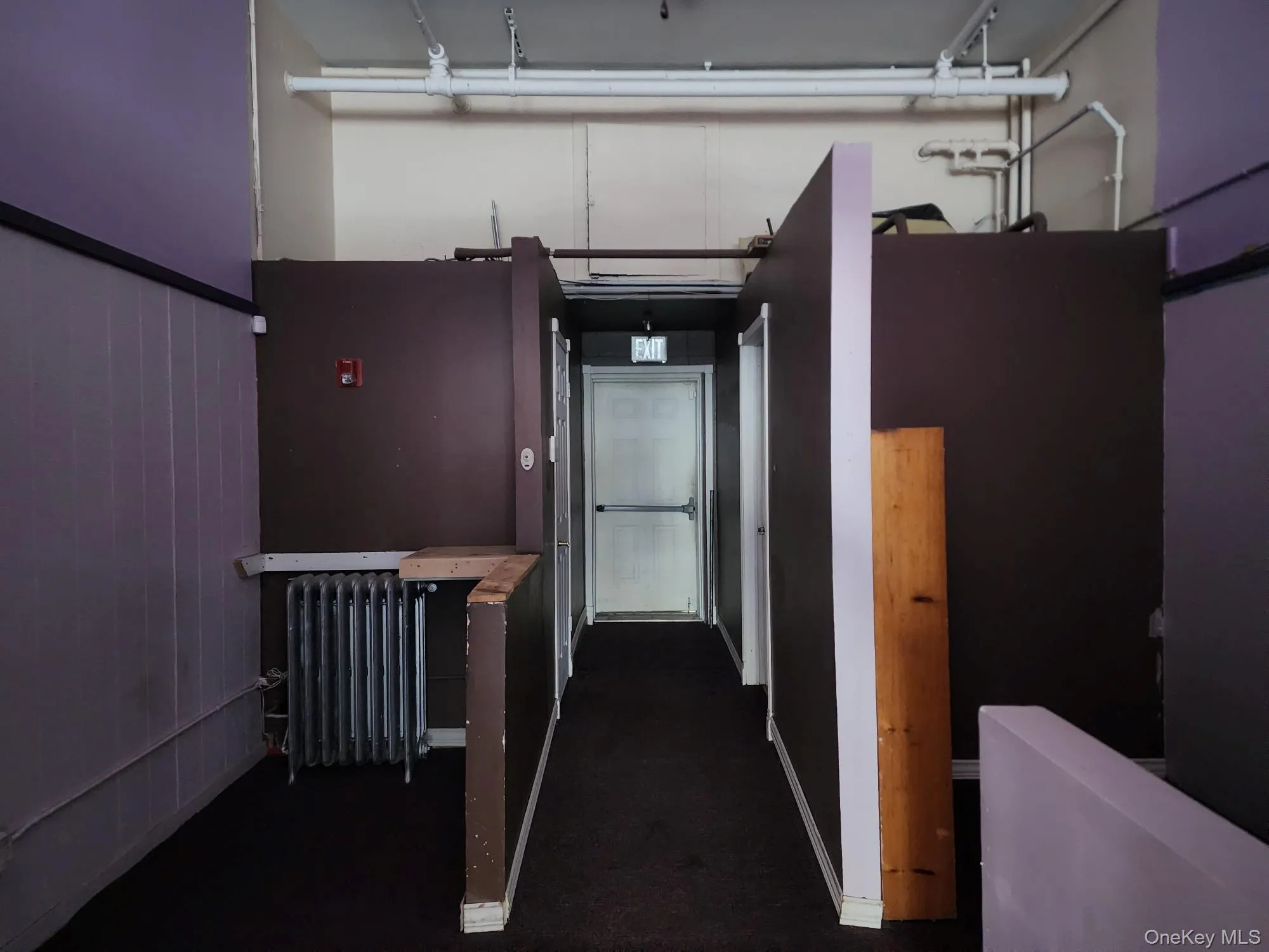Hall with radiator and dark colored carpet Hall with radiator and dark colored carpet