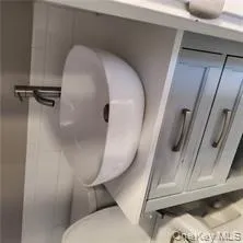 Bathroom view of vanity, tile walls, and wainscoting Bathroom view of vanity, tile walls, and wainscoting