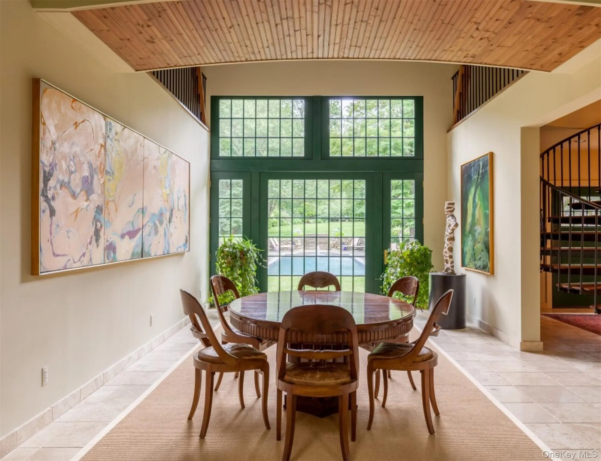 Tiled dining space featuring wooden ceiling, plenty of natural light, stairs, and a high ceiling Tiled dining space featuring wooden ceiling, plenty of natural light, stairs, and a high ceiling