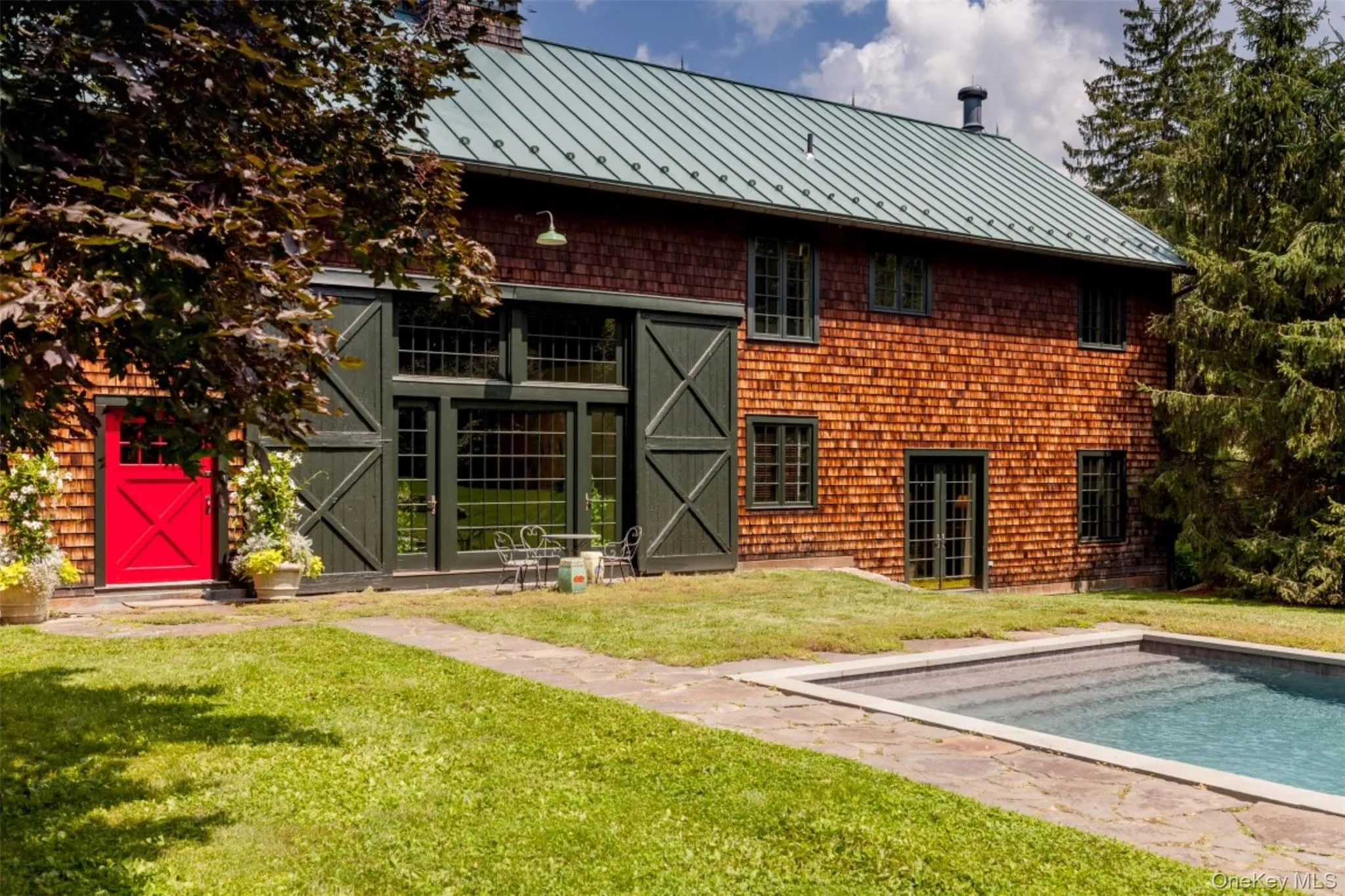 Rear view of property with a standing seam roof, a metal roof, and a lawn Rear view of property with a standing seam roof, a metal roof, and a lawn