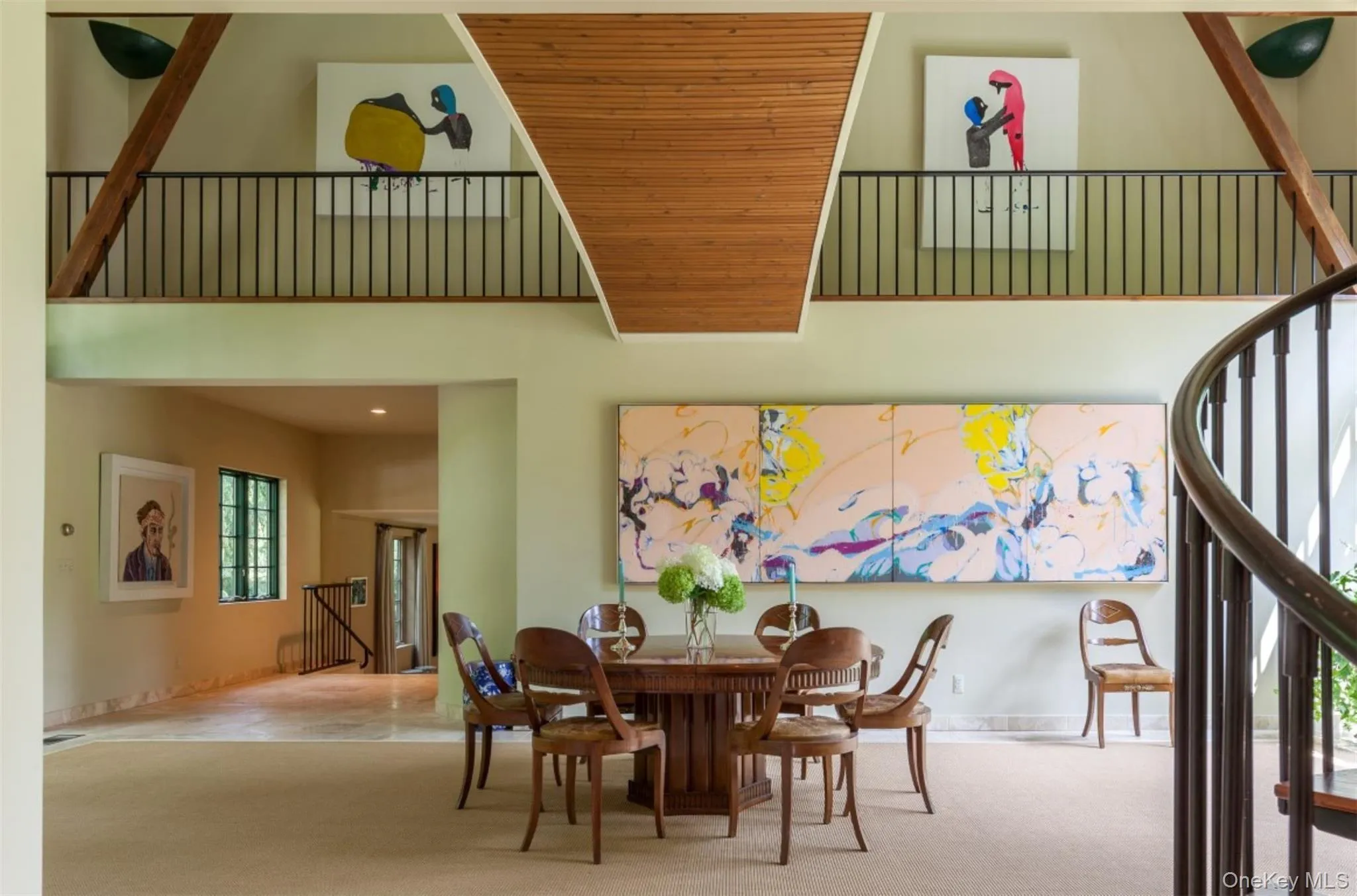 Dining space featuring a high ceiling, carpet flooring, and stairs Dining space featuring a high ceiling, carpet flooring, and stairs