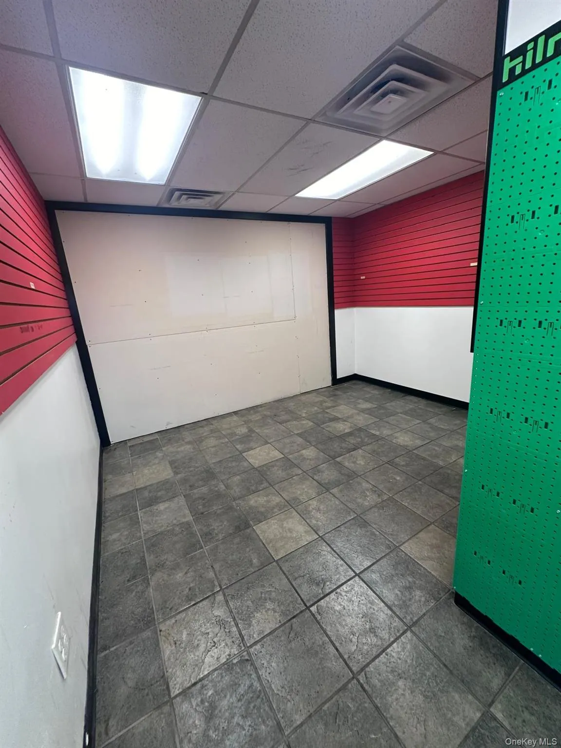 Unfurnished room with a paneled ceiling and dark stone finish floors Unfurnished room with a paneled ceiling and dark stone finish floors