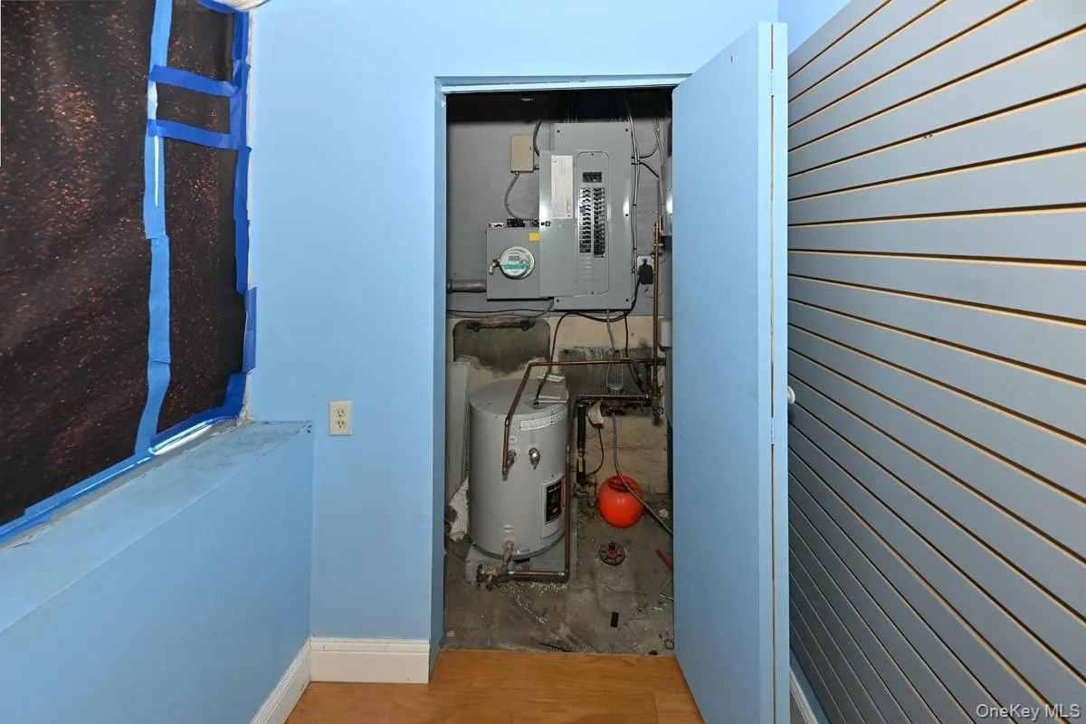 Utility room with electric panel and water heater Utility room with electric panel and water heater
