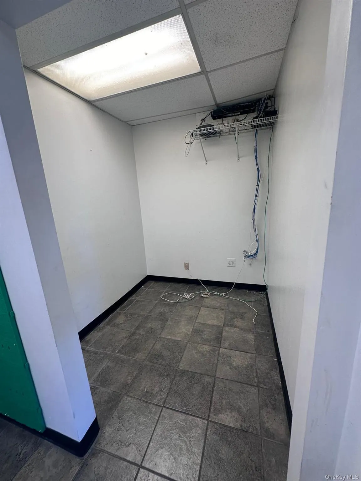 Finished basement with a drop ceiling and dark stone finish floors Finished basement with a drop ceiling and dark stone finish floors