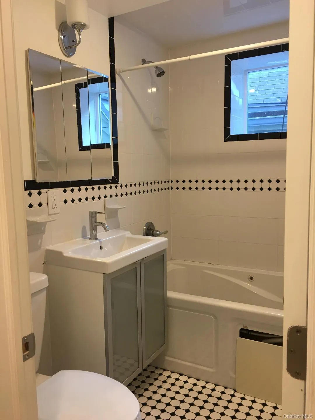 Full bathroom with shower / tub combination, vanity, and tile walls Full bathroom with shower / tub combination, vanity, and tile walls