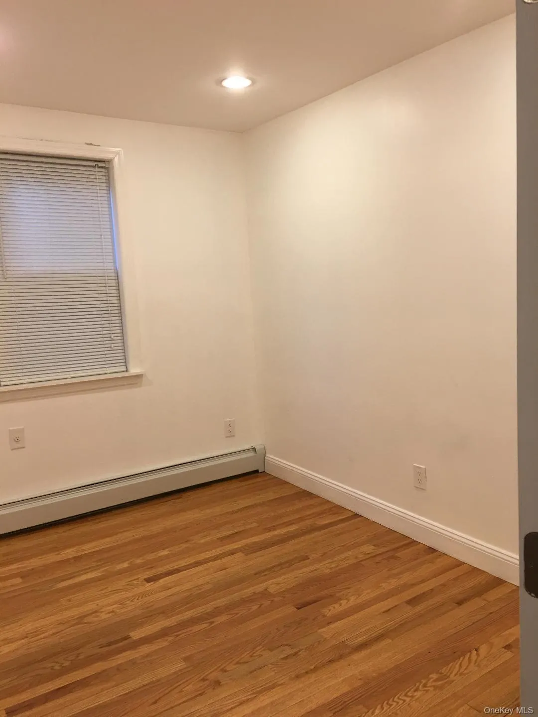 Unfurnished room with light wood-style flooring, baseboard heating, and recessed lighting Unfurnished room with light wood-style flooring, baseboard heating, and recessed lighting