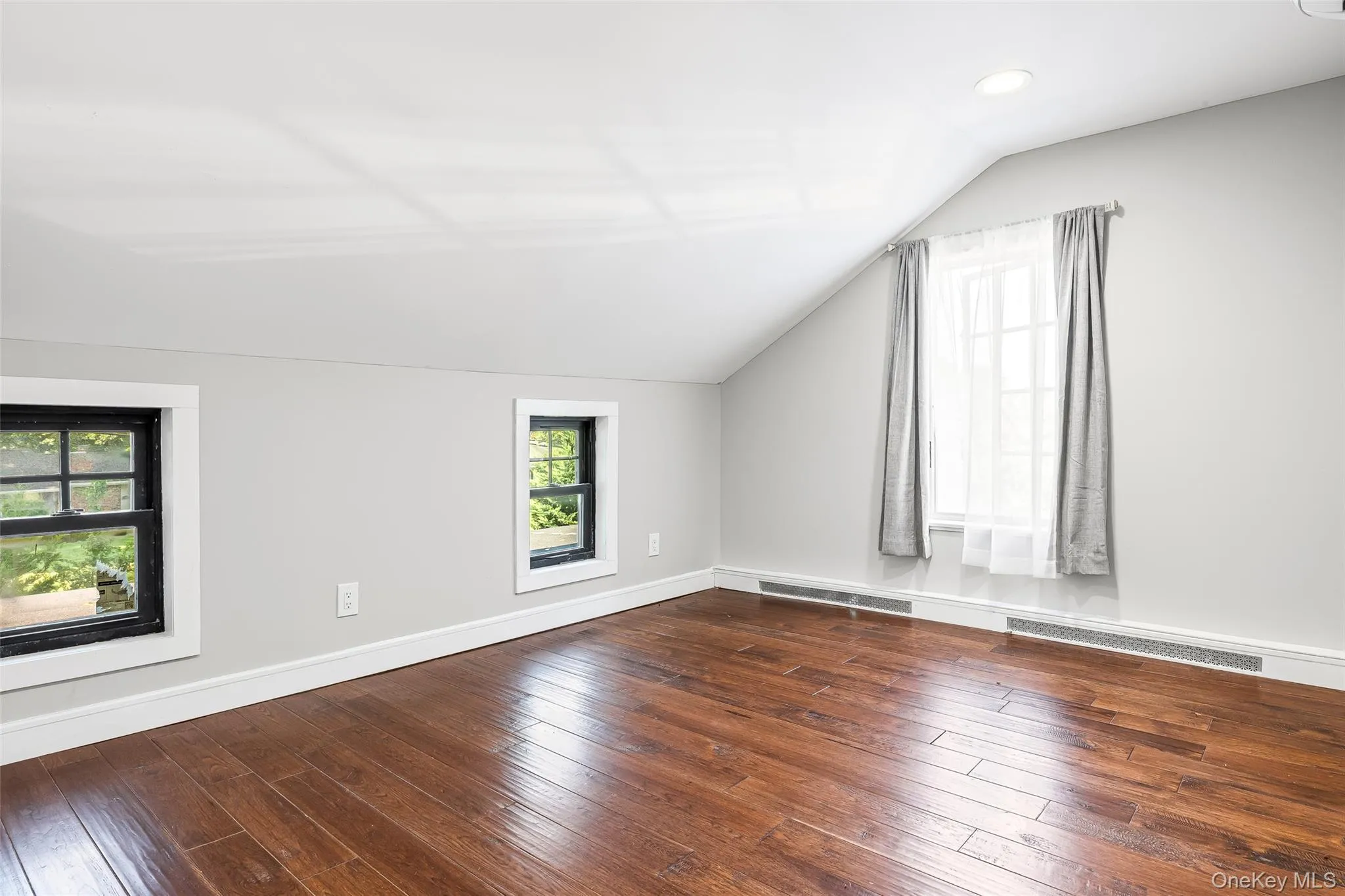 Bonus room featuring vaulted ceiling and dark wood-style floors Bonus room featuring vaulted ceiling and dark wood-style floors