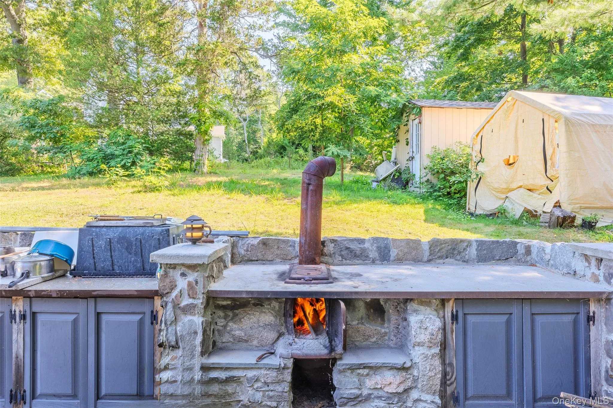 View of patio / terrace featuring an outdoor structure and view of scattered trees View of patio / terrace featuring an outdoor structure and view of scattered trees