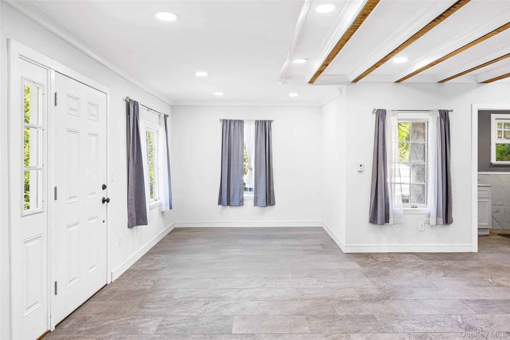 Foyer with ornamental molding, recessed lighting, and light wood-type flooring Foyer with ornamental molding, recessed lighting, and light wood-type flooring