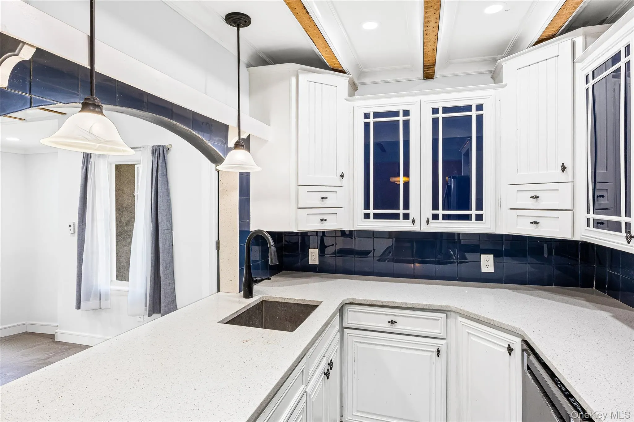 Kitchen featuring light stone countertops, tasteful backsplash, white cabinets, recessed lighting, and beam ceiling Kitchen featuring light stone countertops, tasteful backsplash, white cabinets, recessed lighting, and beam ceiling