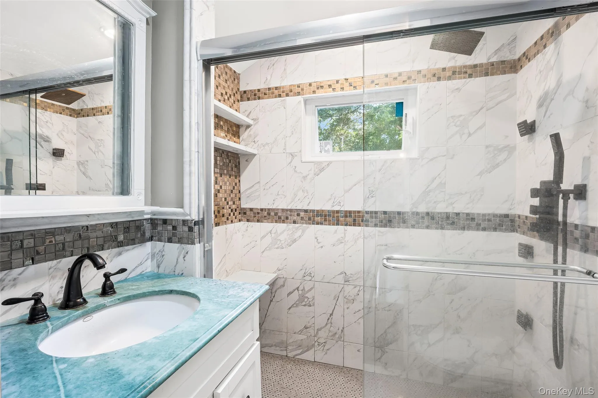 Full bath featuring a marble finish shower, vanity, and tile walls Full bath featuring a marble finish shower, vanity, and tile walls