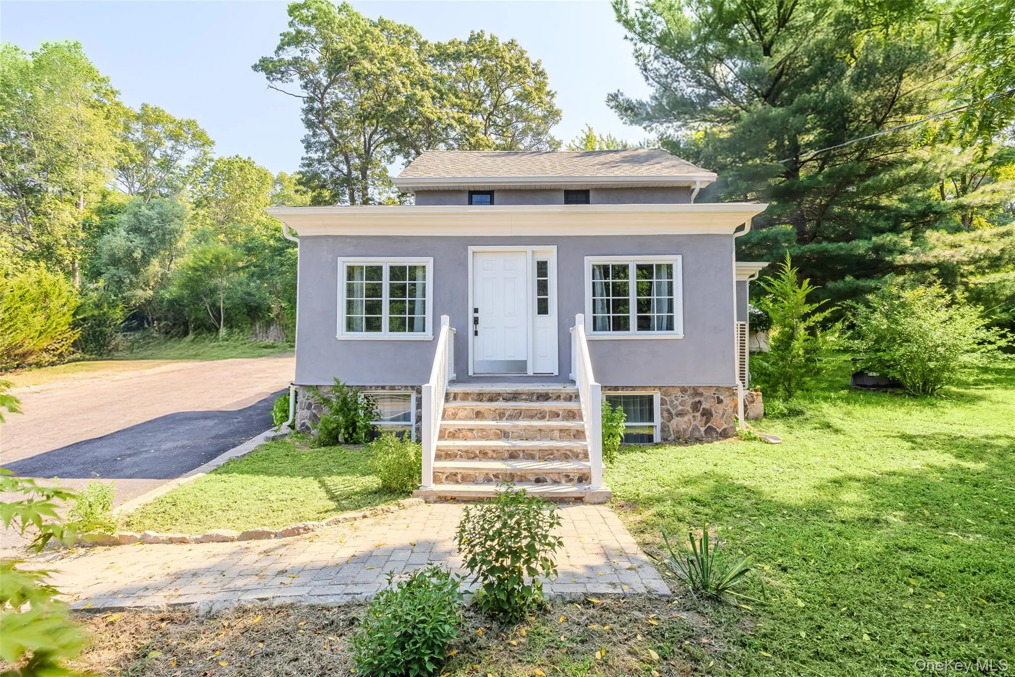 Bungalow-style home featuring stucco siding and a front yard Bungalow-style home featuring stucco siding and a front yard