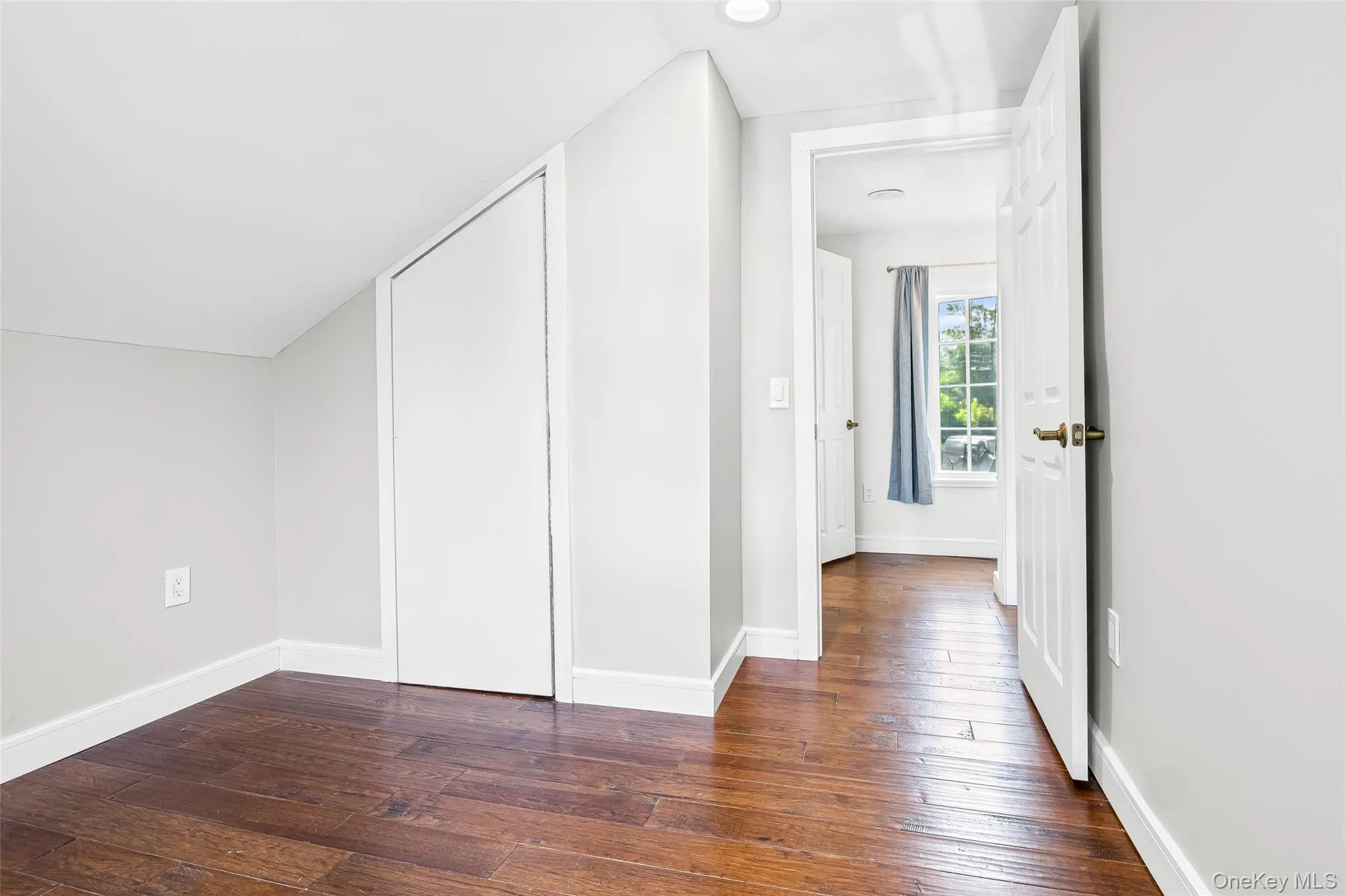 Bonus room with dark wood-style floors and baseboards Bonus room with dark wood-style floors and baseboards