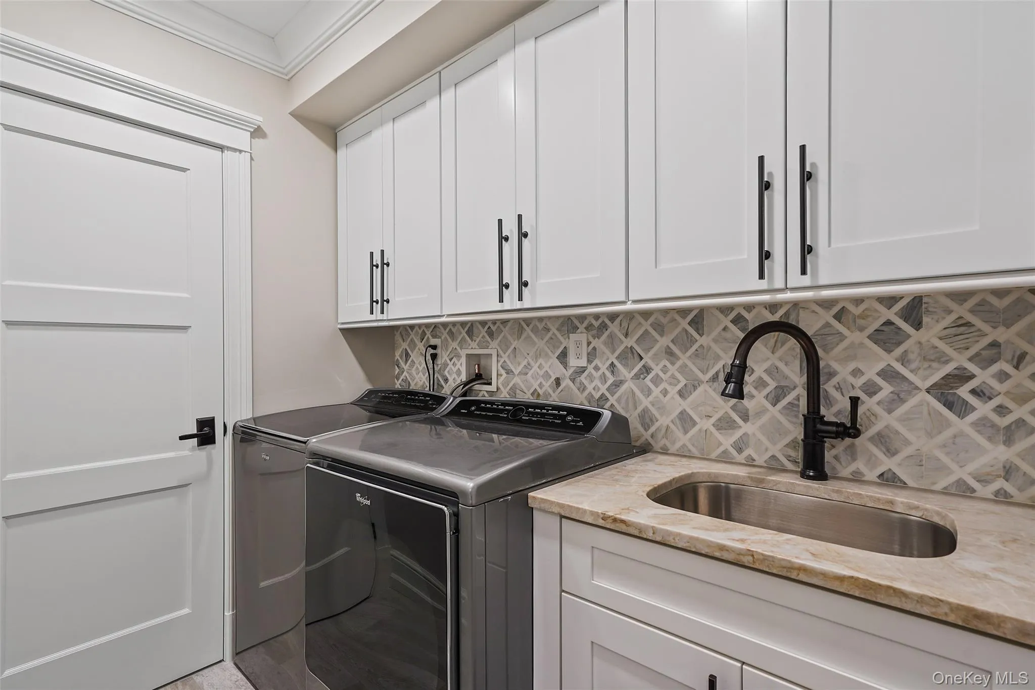 Laundry area featuring washer and clothes dryer, crown molding, and cabinet space Laundry area featuring washer and clothes dryer, crown molding, and cabinet space