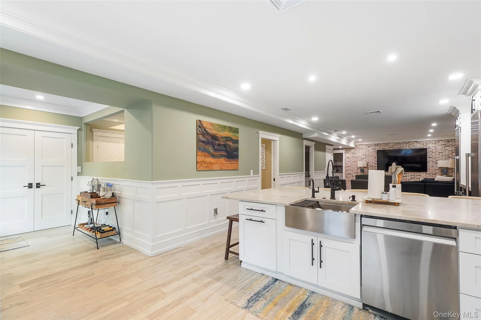 Kitchen featuring stainless steel appliances, open floor plan, recessed lighting, white cabinets, and light stone counters Kitchen featuring stainless steel appliances, open floor plan, recessed lighting, white cabinets, and light stone counters