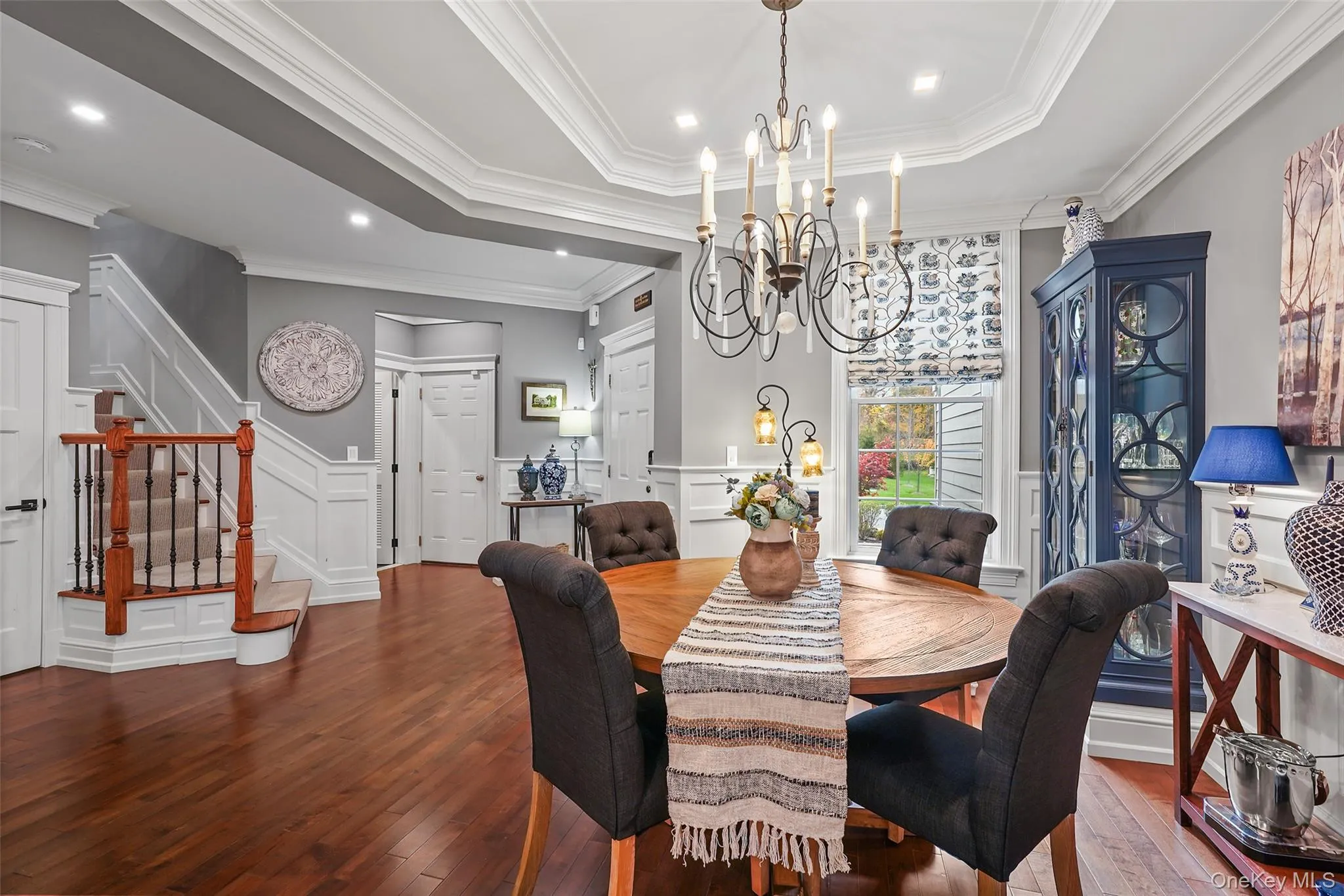 Dining area with a decorative wall, stairway, hardwood / wood-style floors, ornamental molding Dining area with a decorative wall, stairway, hardwood / wood-style floors, ornamental molding