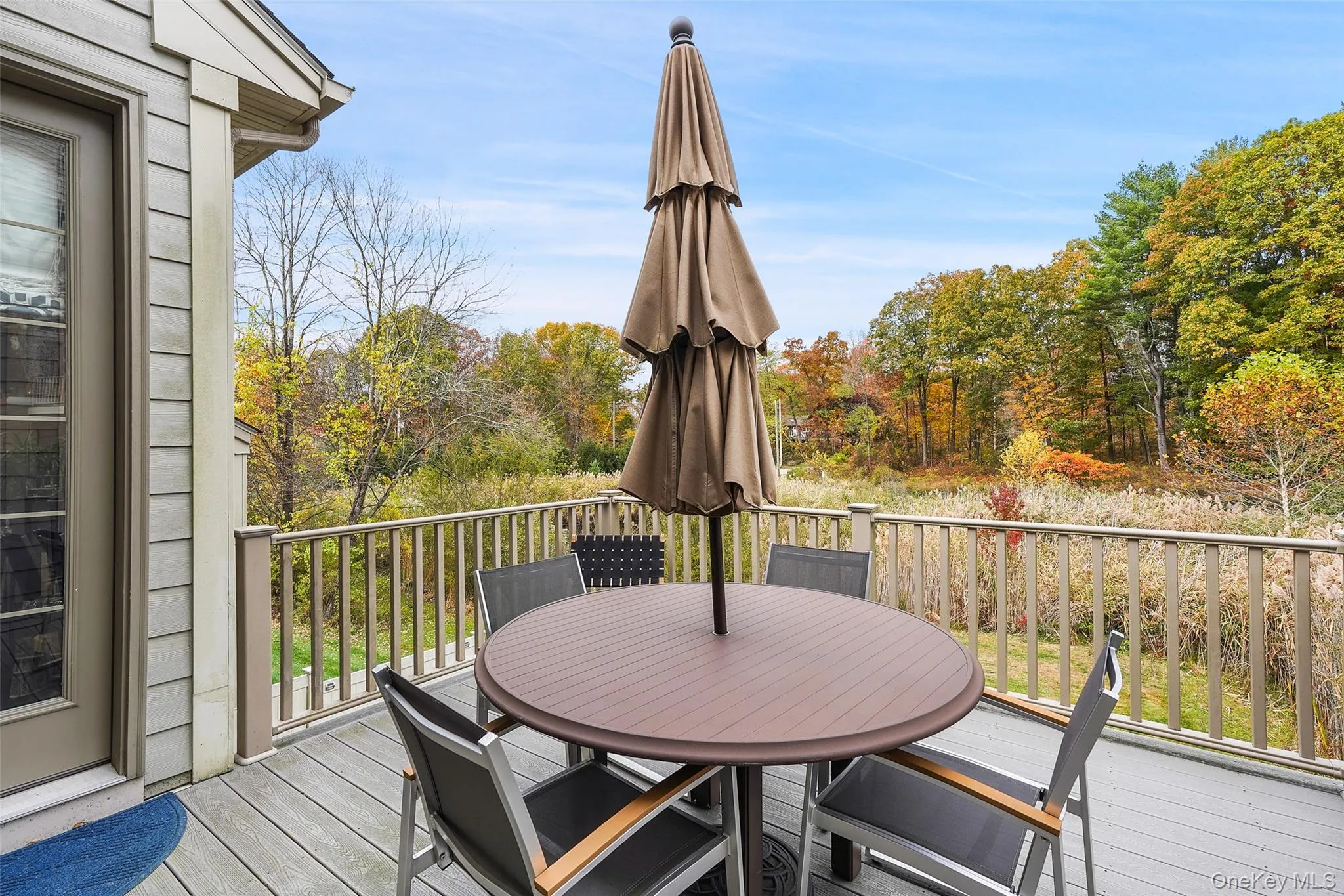 Trex terrace with outdoor dining area and view of wooded area Trex terrace with outdoor dining area and view of wooded area