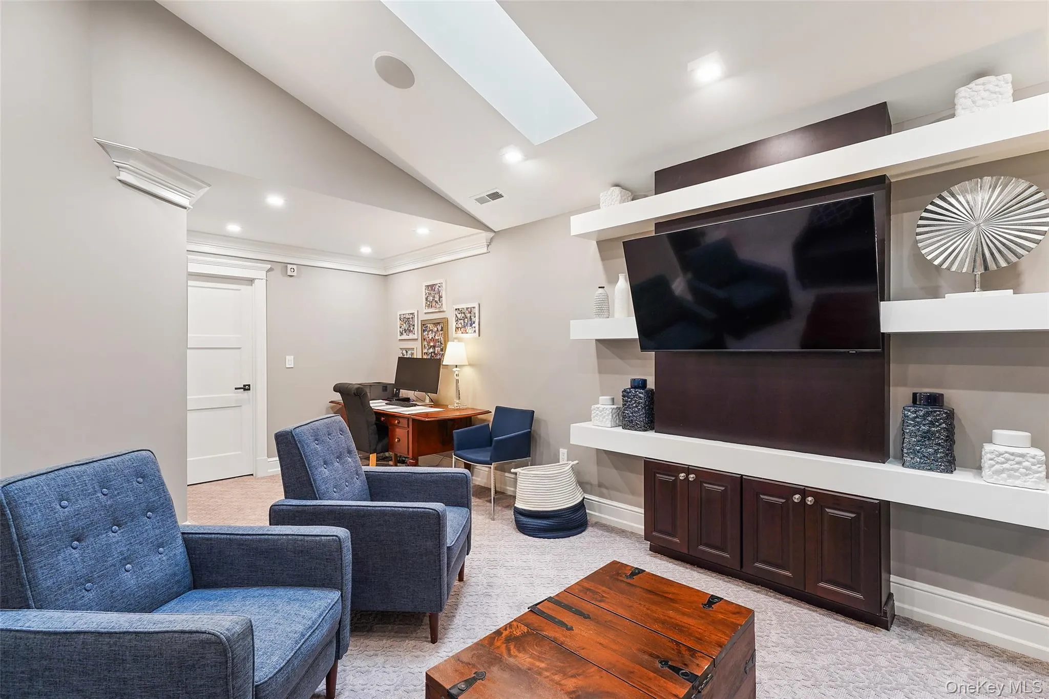 Living area with a desk, light carpet, recessed lighting, a skylight, and high vaulted ceiling Living area with a desk, light carpet, recessed lighting, a skylight, and high vaulted ceiling