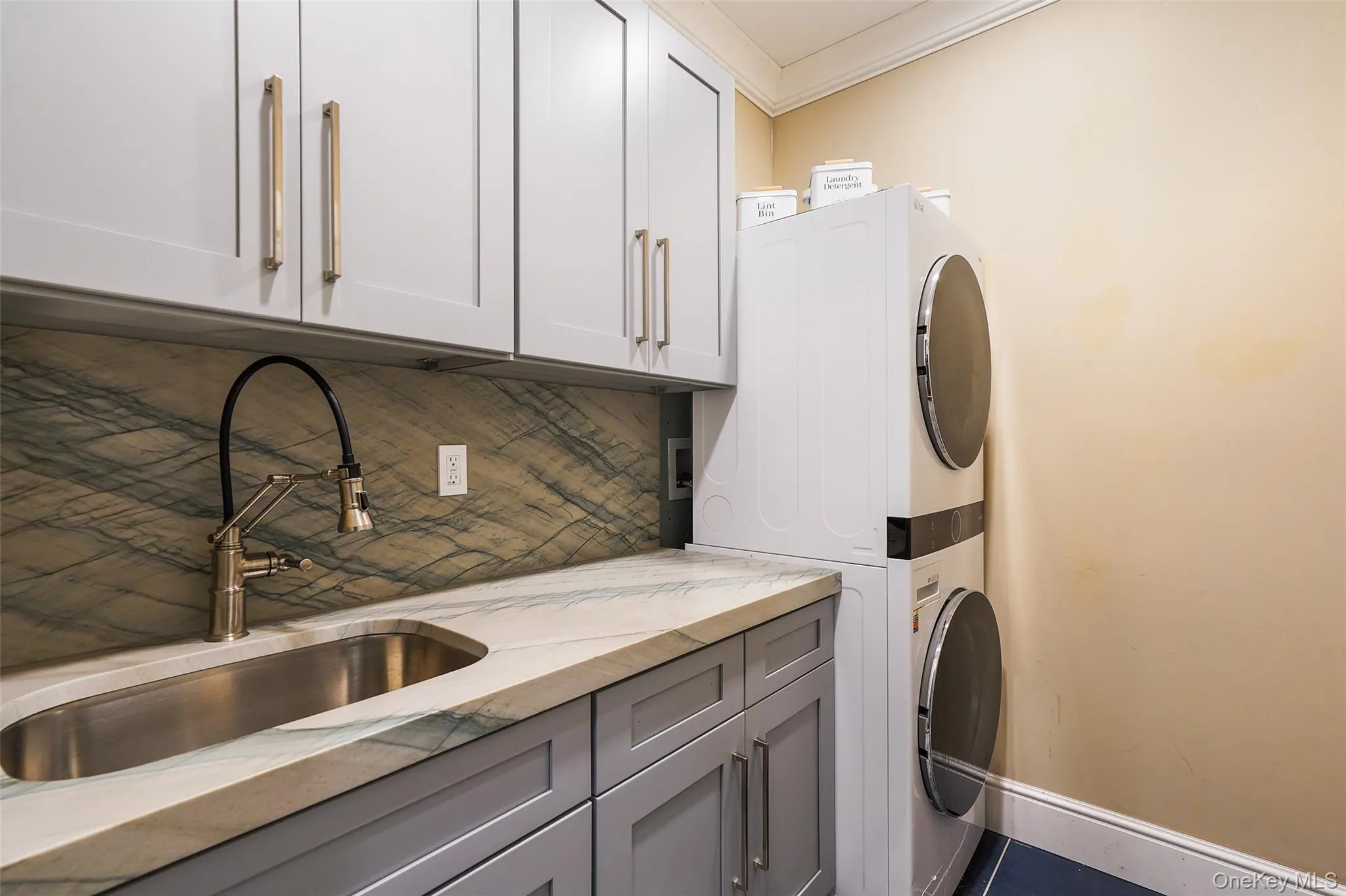 Laundry room #1 featuring cabinet space, stacked washer / dryer, and ornamental molding Laundry room #1 featuring cabinet space, stacked washer / dryer, and ornamental molding