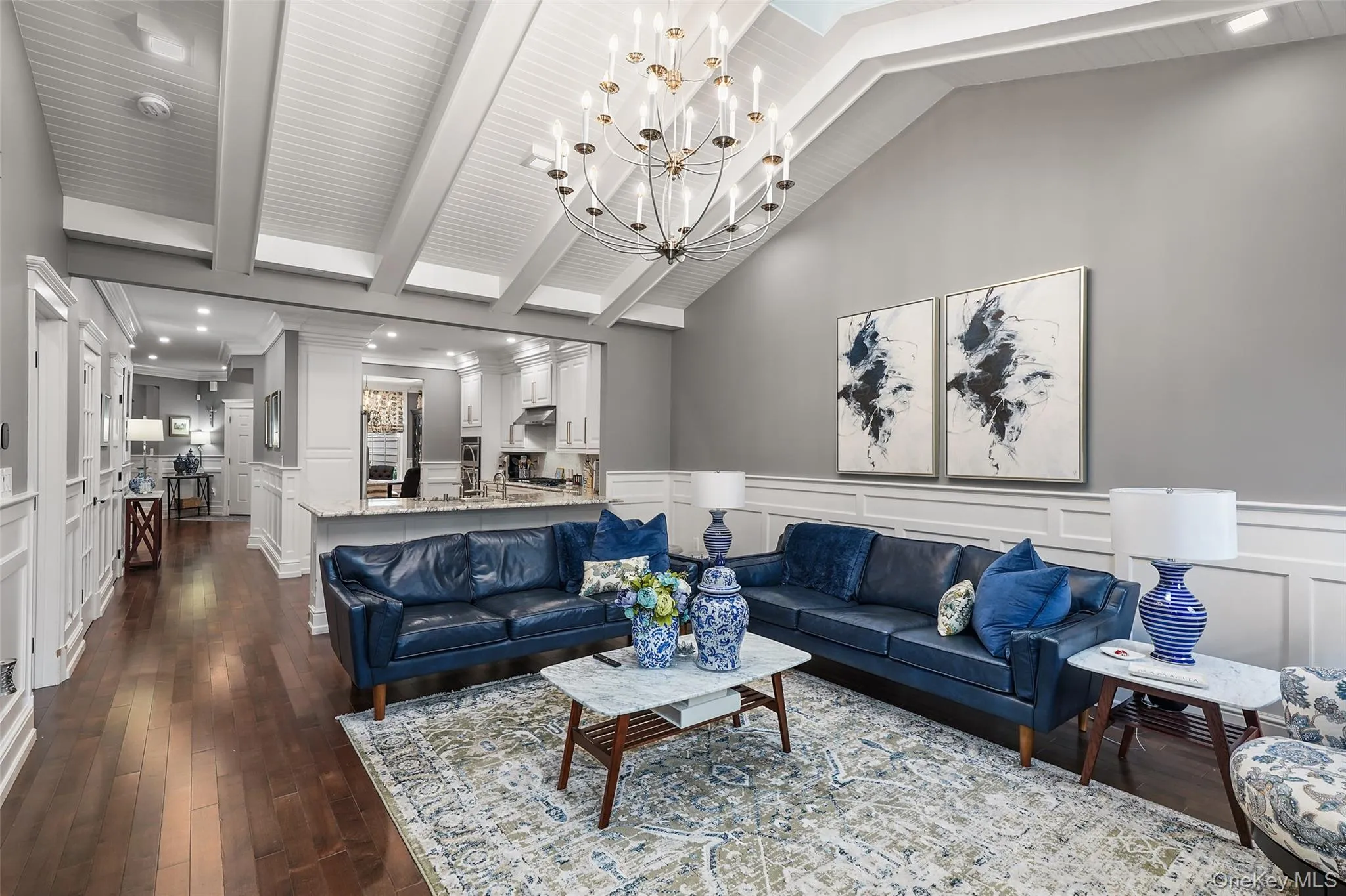 Living room with a decorative wall, a chandelier, dark wood-type flooring, a wainscoted wall, and recessed lighting Living room with a decorative wall, a chandelier, dark wood-type flooring, a wainscoted wall, and recessed lighting