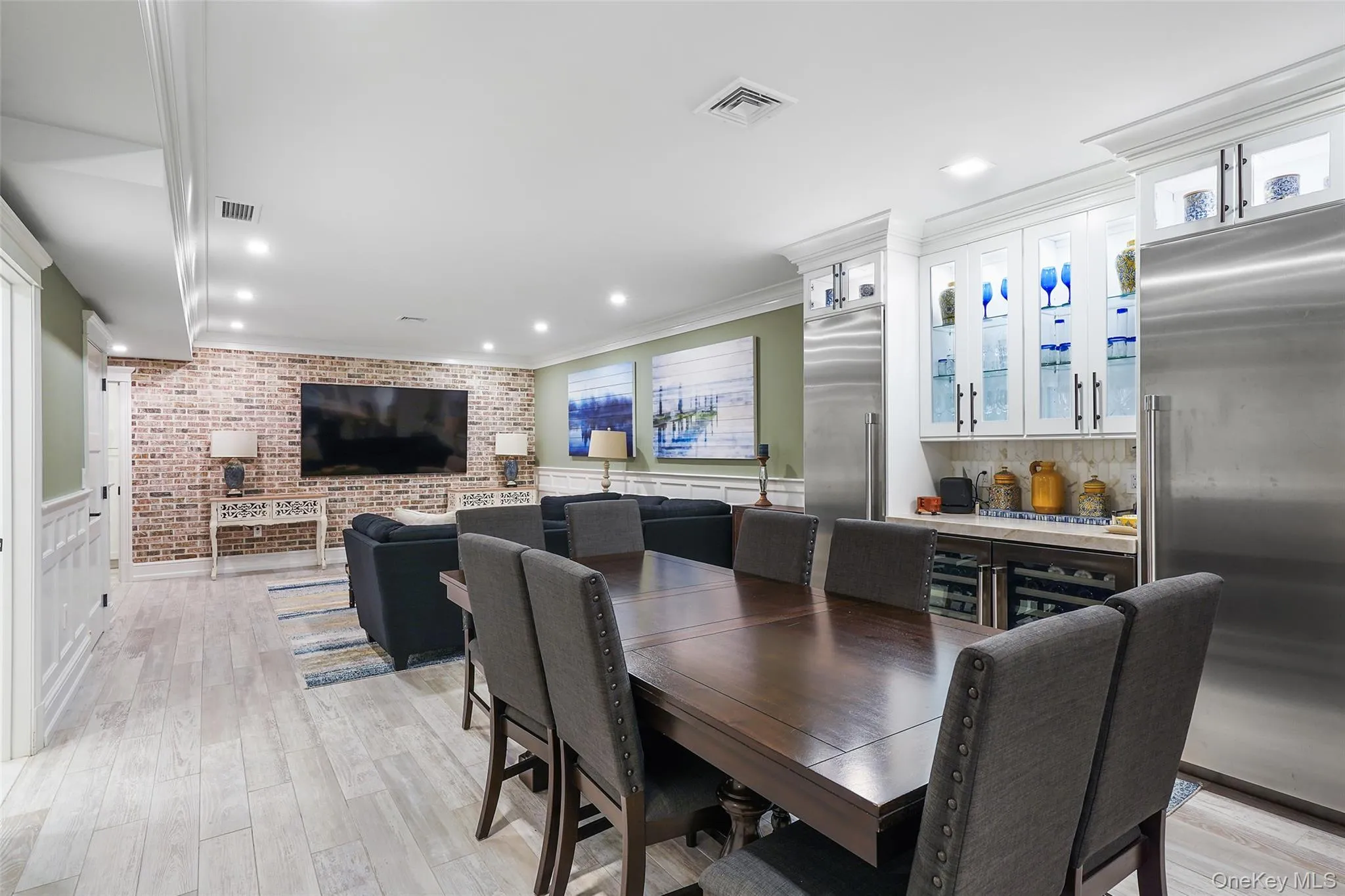 Dining area with crown molding, light wood-type flooring, recessed lighting, and brick wall Dining area with crown molding, light wood-type flooring, recessed lighting, and brick wall