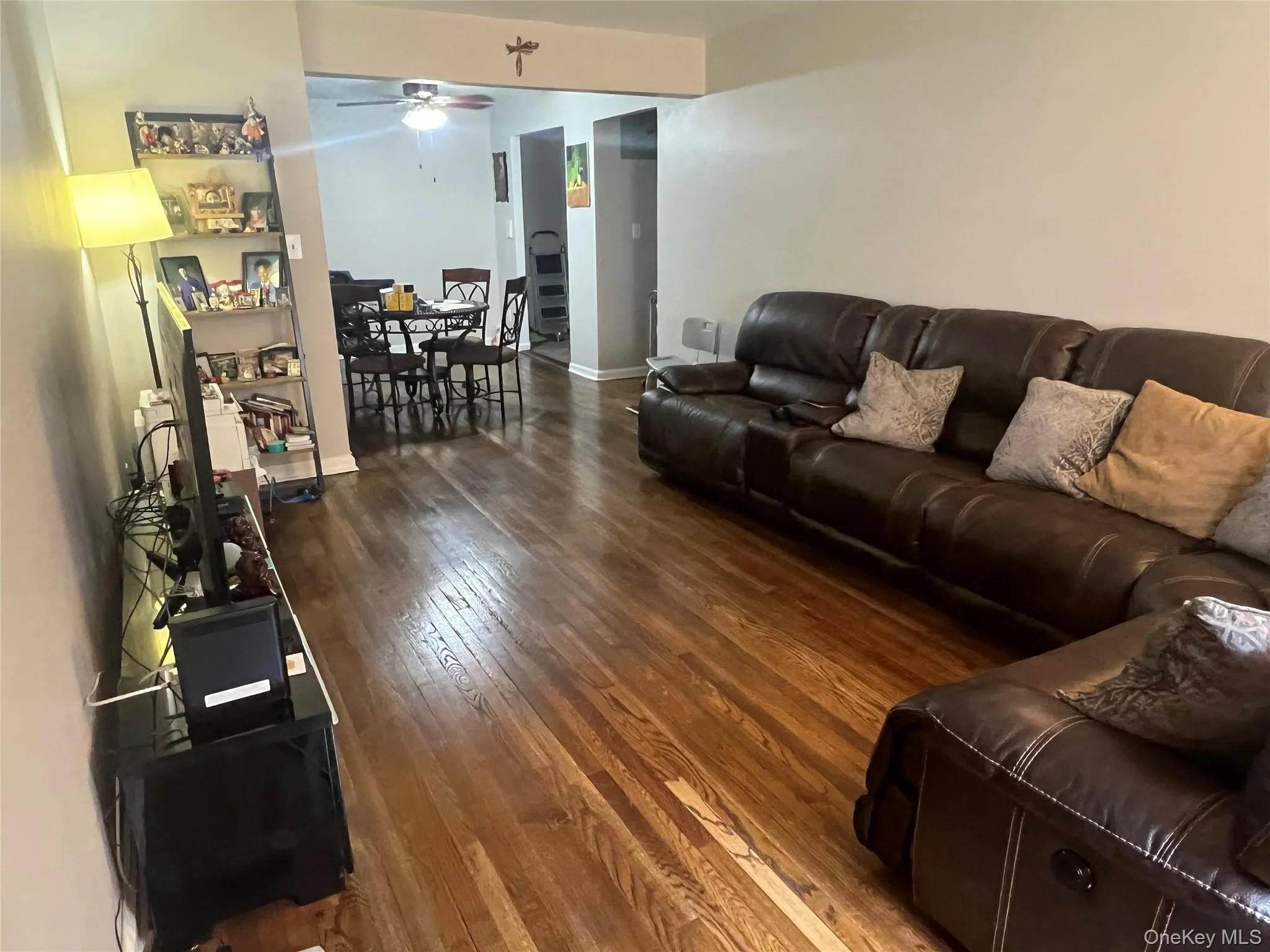 Living room featuring hardwood / wood-style floors, ceiling fan, and baseboards Living room featuring hardwood / wood-style floors, ceiling fan, and baseboards