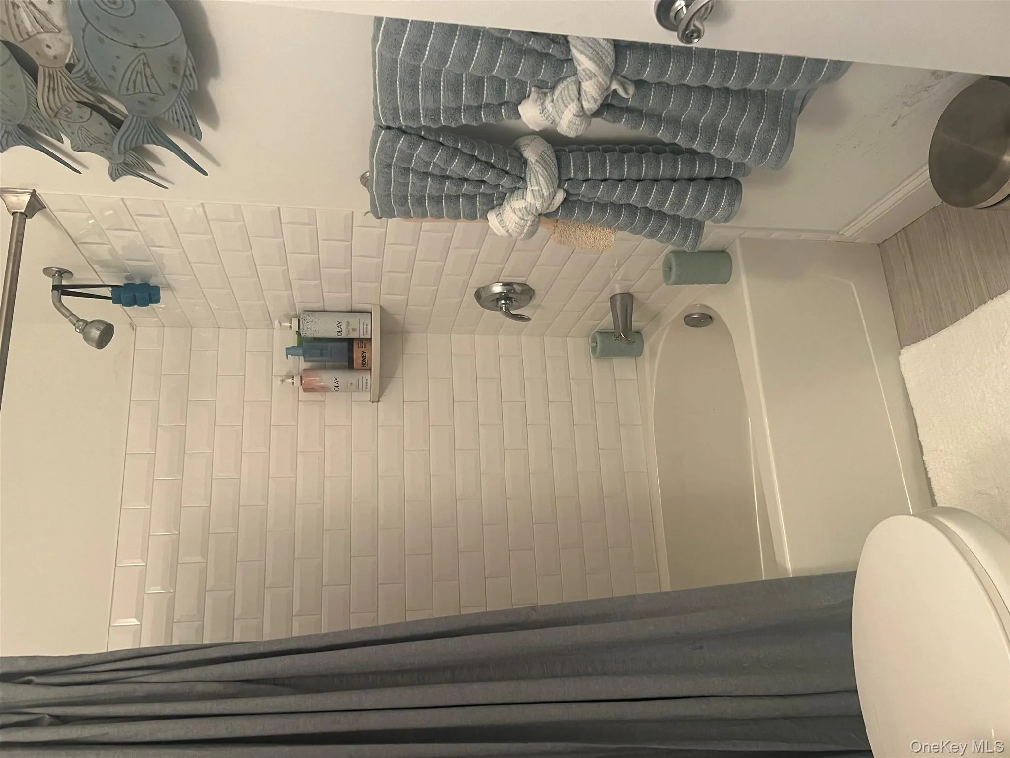 Full bath with shower / bath combination with curtain and light wood-style flooring Full bath with shower / bath combination with curtain and light wood-style flooring