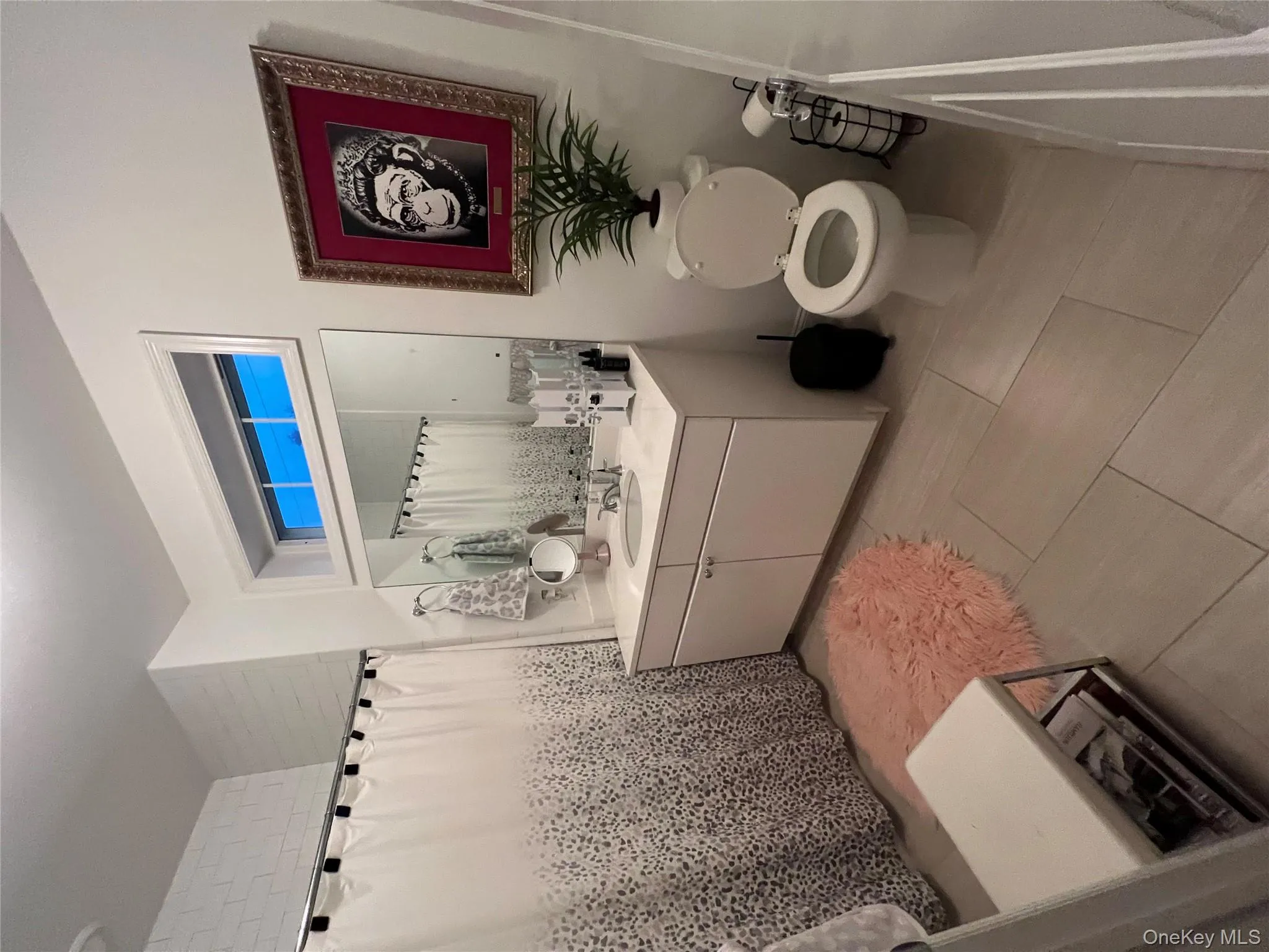 Bathroom with curtained shower, vanity, and light tile patterned flooring Bathroom with curtained shower, vanity, and light tile patterned flooring