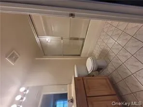 Full bathroom featuring vanity, light tile patterned floors, and shower / bath combination with glass door Full bathroom featuring vanity, light tile patterned floors, and shower / bath combination with glass door