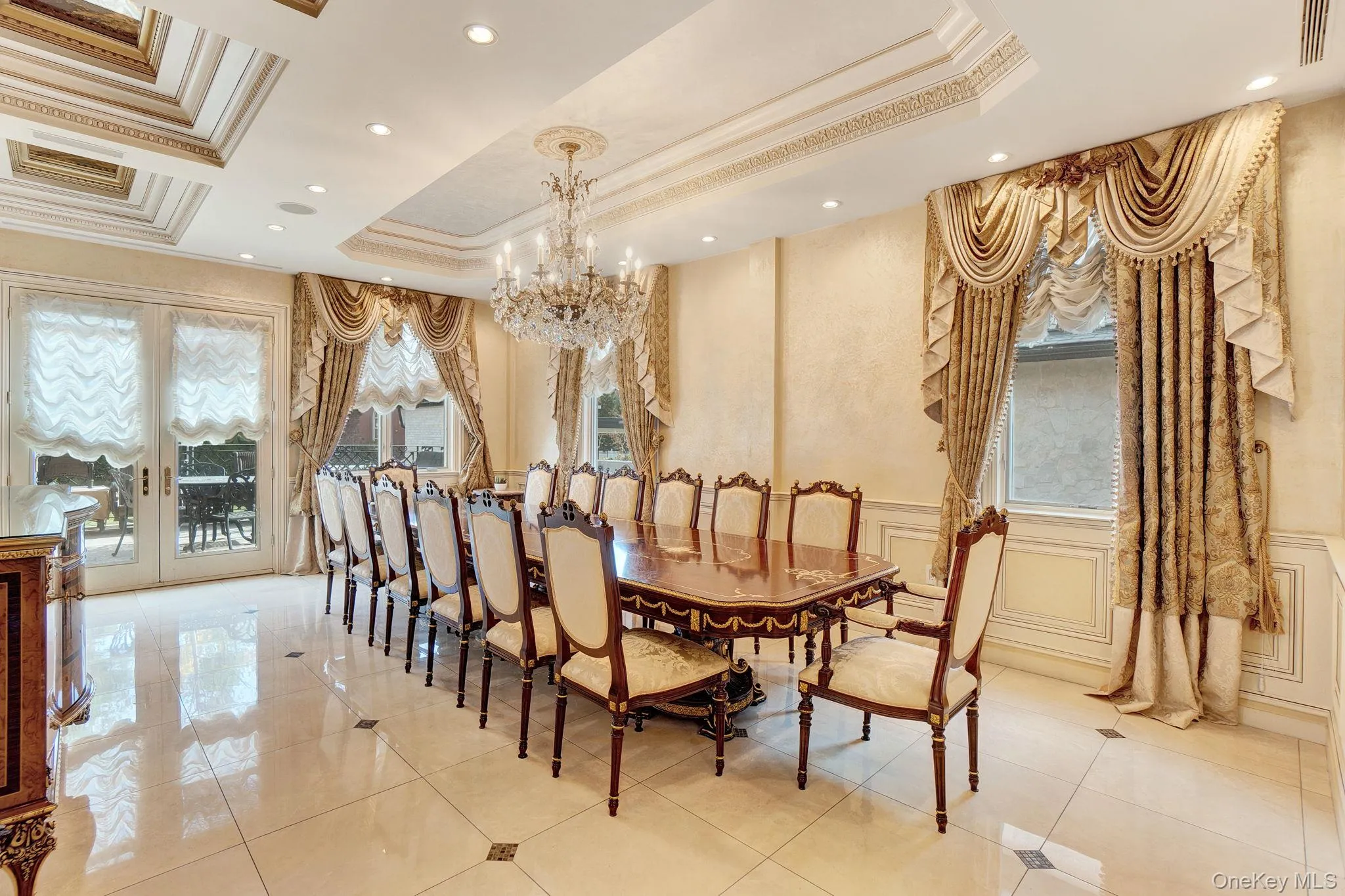 Dining room featuring a decorative wall, crown molding, a chandelier, a raised ceiling, and wainscoting Dining room featuring a decorative wall, crown molding, a chandelier, a raised ceiling, and wainscoting