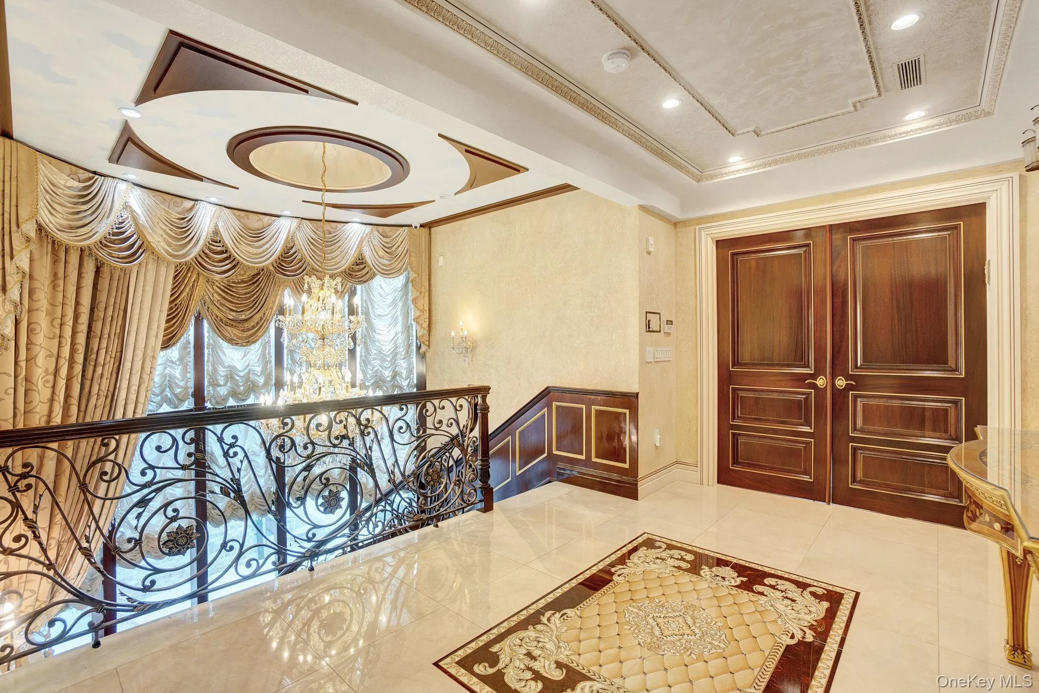 Hall featuring ornamental molding, a chandelier, a raised ceiling, recessed lighting, and tile patterned flooring Hall featuring ornamental molding, a chandelier, a raised ceiling, recessed lighting, and tile patterned flooring