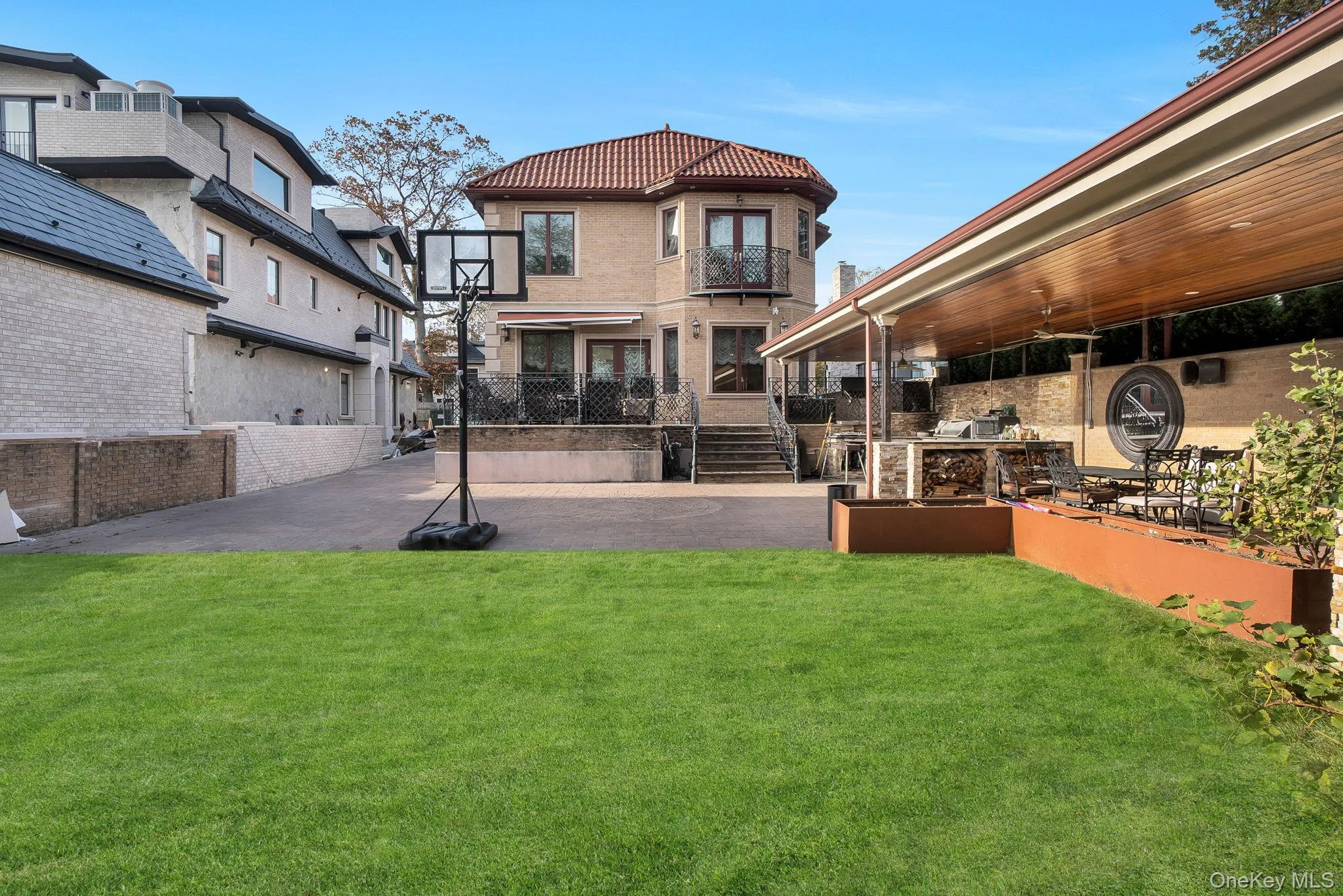 Rear view of property featuring a yard, a patio, a tile roof, and a balcony Rear view of property featuring a yard, a patio, a tile roof, and a balcony