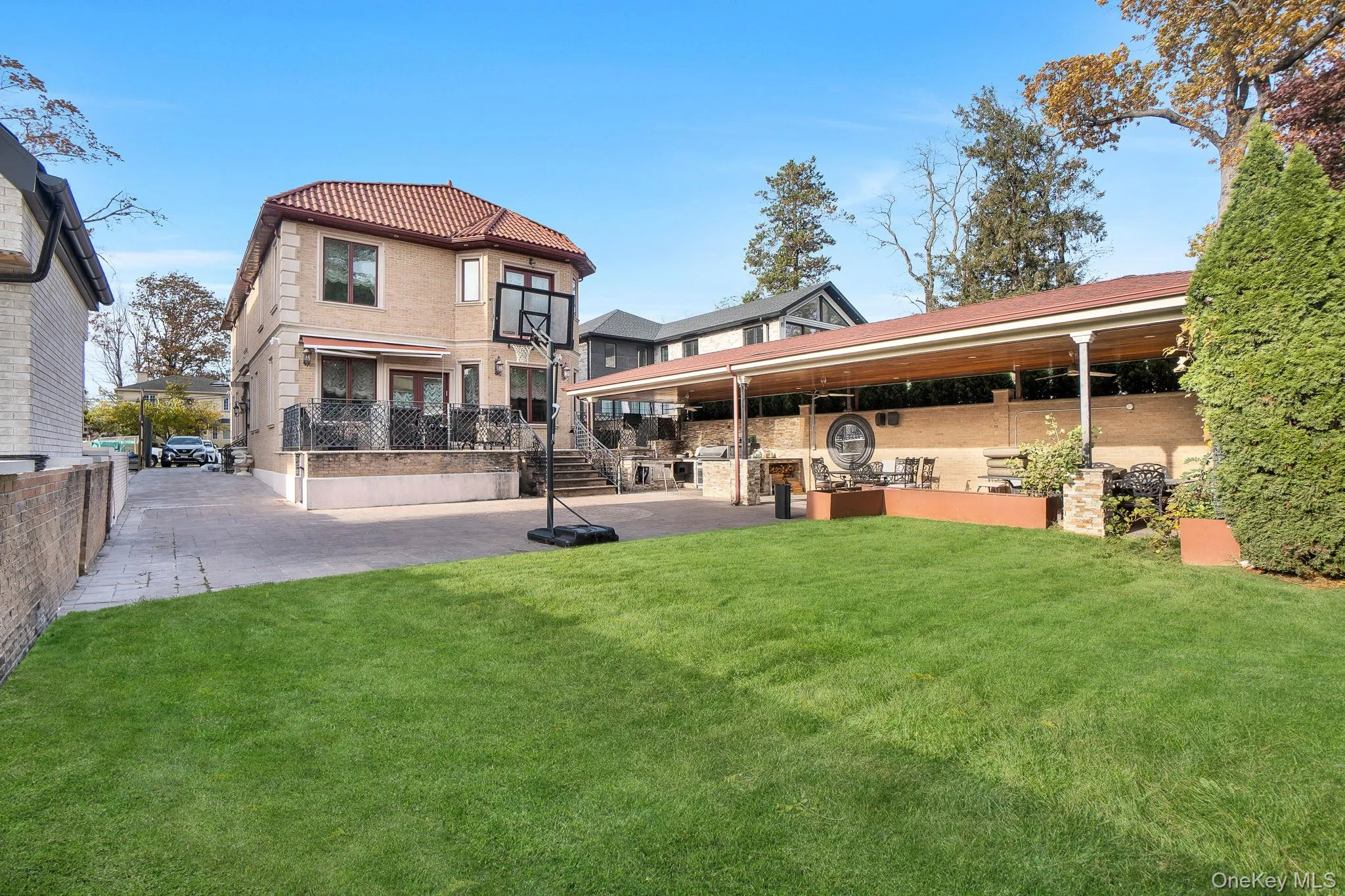 Rear view of house with a lawn, a patio area, and a tile roof Rear view of house with a lawn, a patio area, and a tile roof