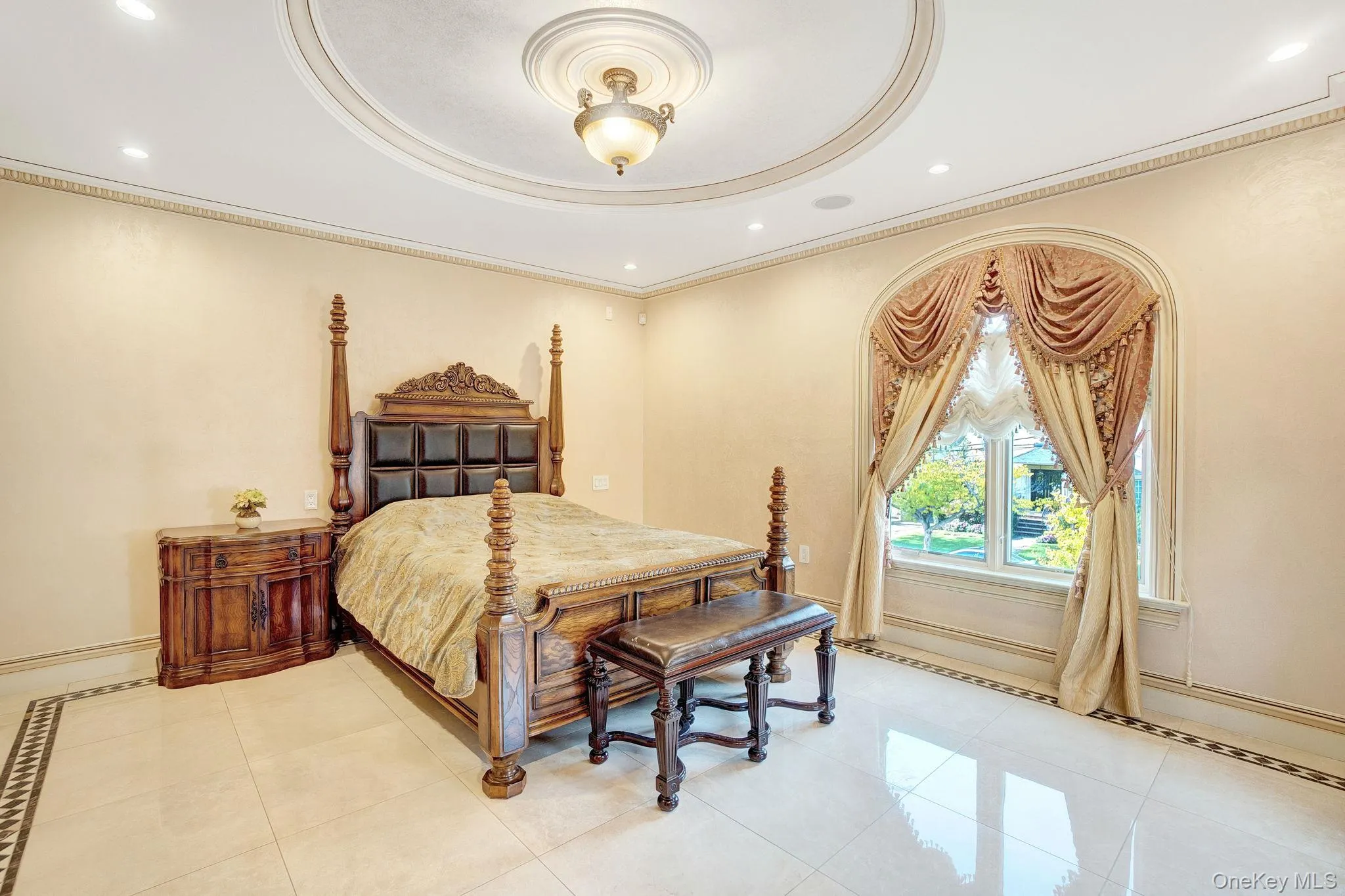 Bedroom with recessed lighting, light tile patterned flooring, crown molding, and a raised ceiling Bedroom with recessed lighting, light tile patterned flooring, crown molding, and a raised ceiling